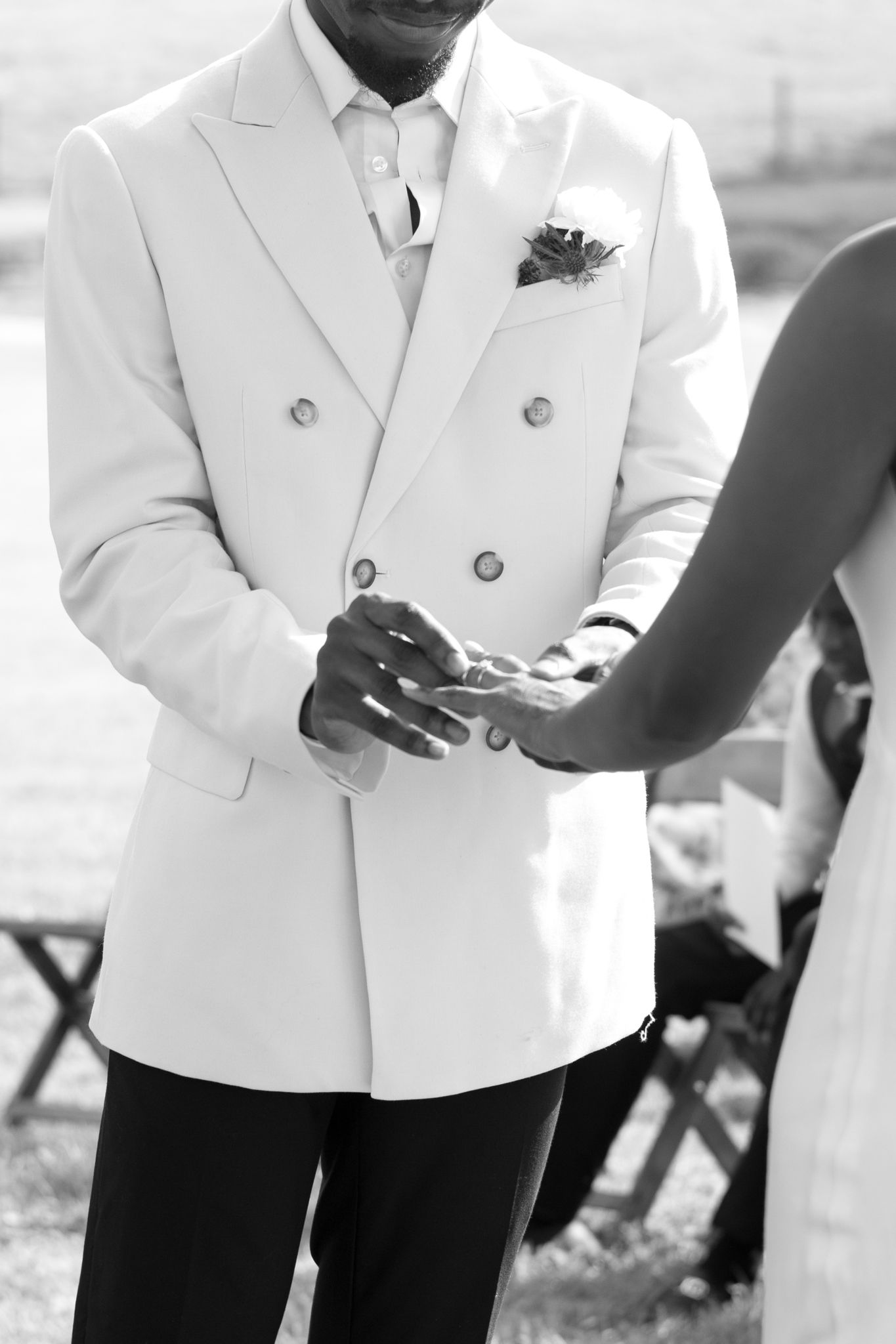 Formal white tuxedo jackets and black pants shown in wedding day detail shots.