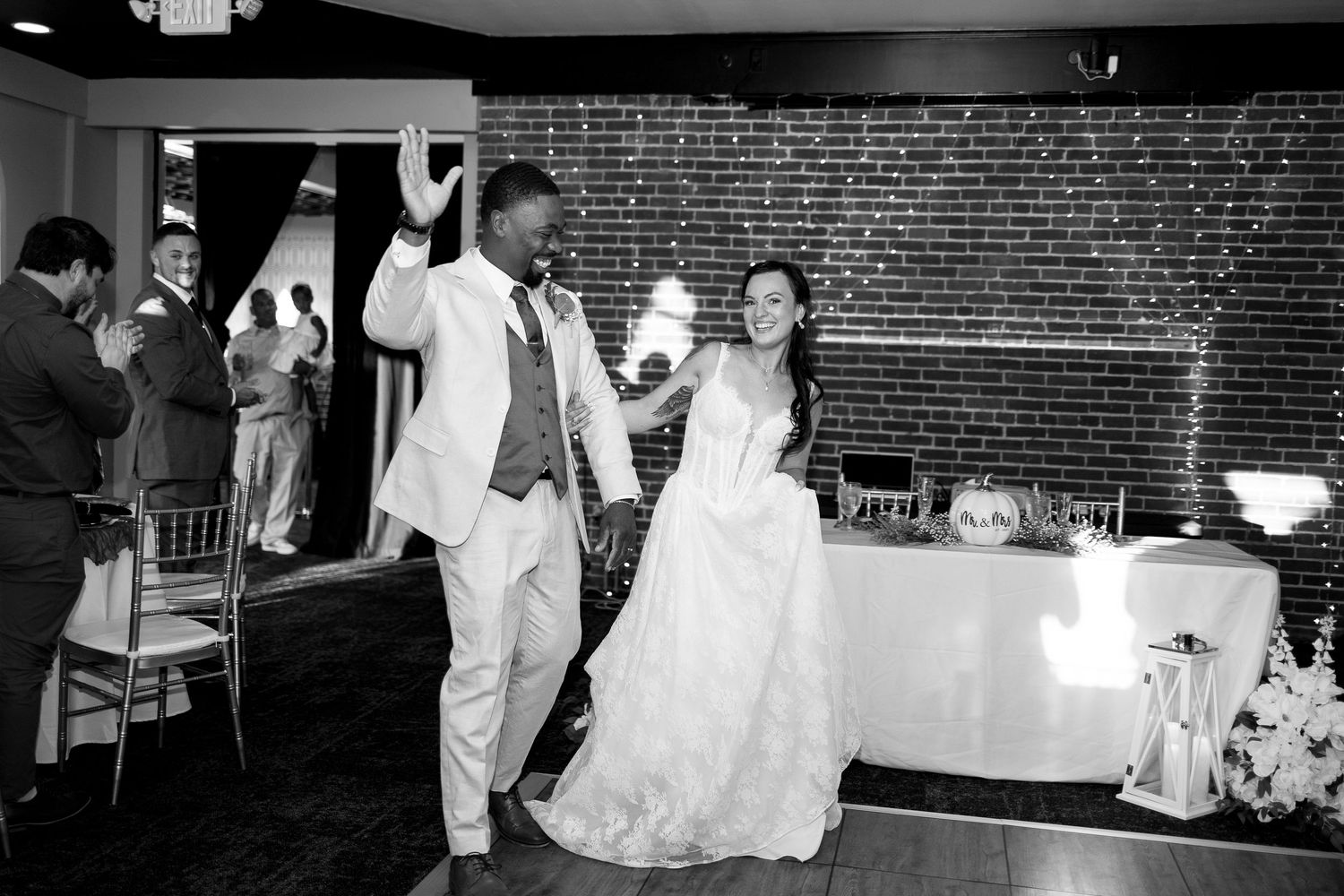 Wedding reception venue with exposed brick walls and dance floor setup.