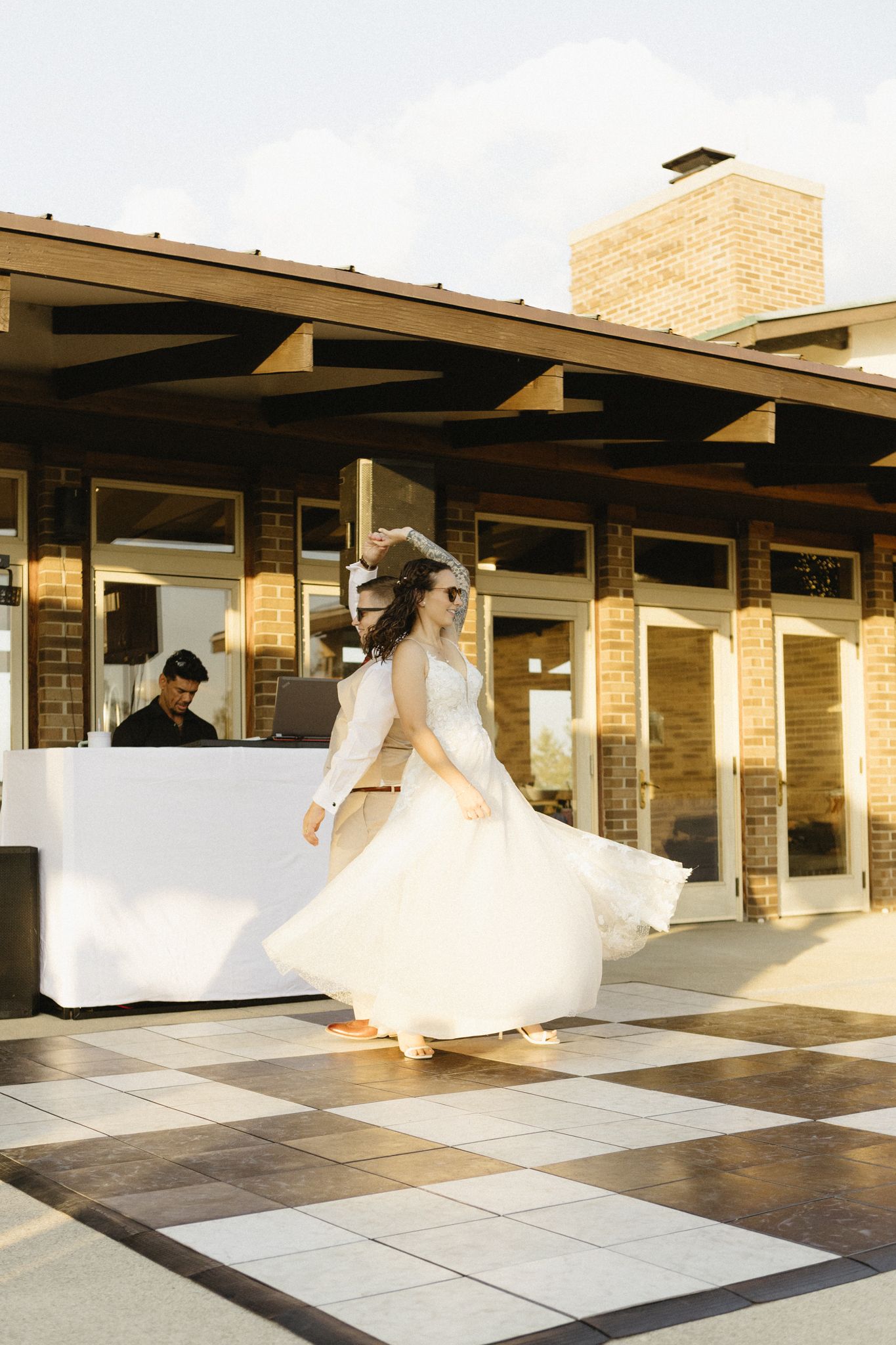 Sequence showing a flowing white wedding dress billowing in the wind against a modern brick building exterior.
