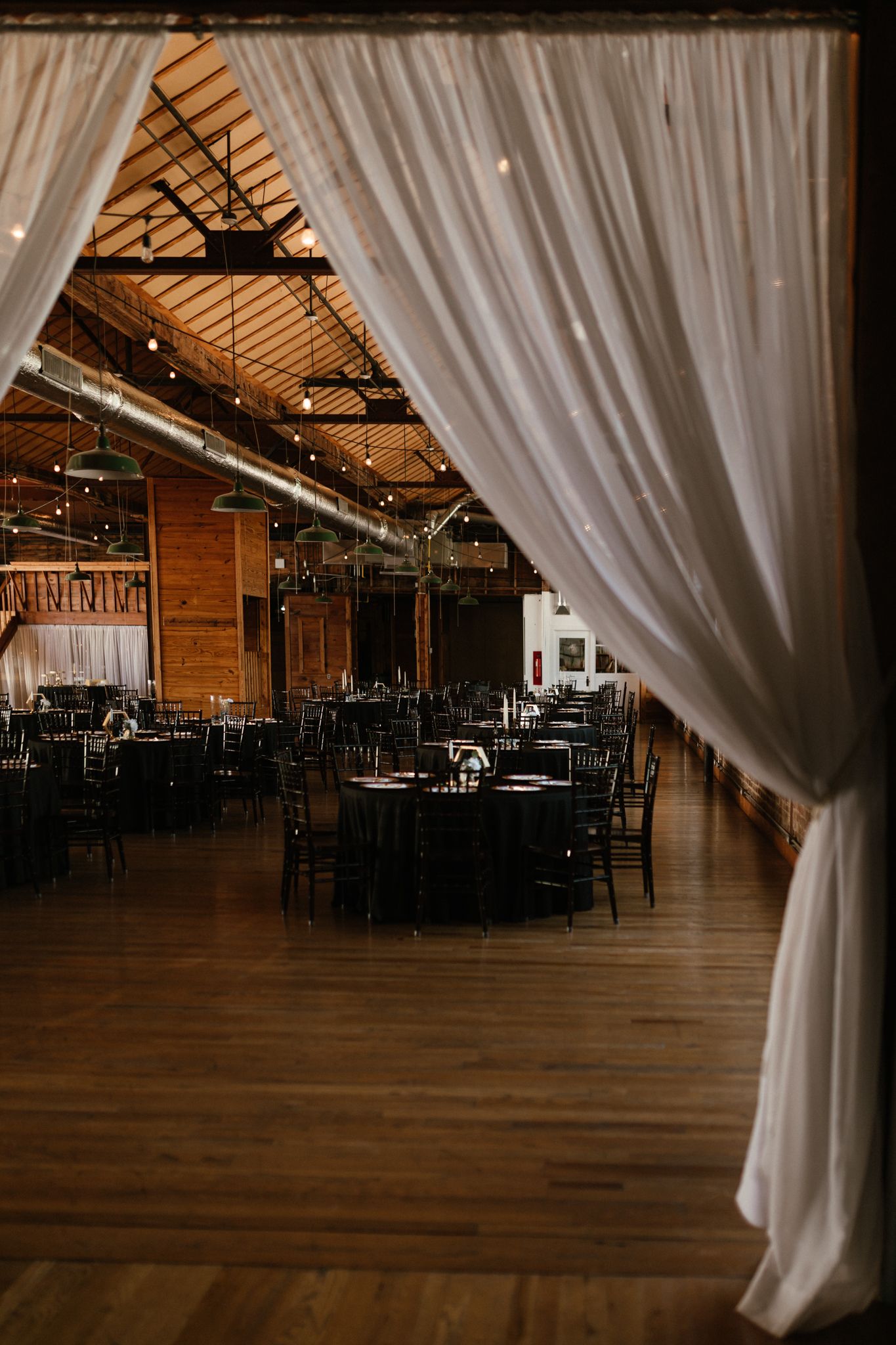 A beautifully set long table adorned with flickering candles and lush greenery, creating an inviting atmosphere