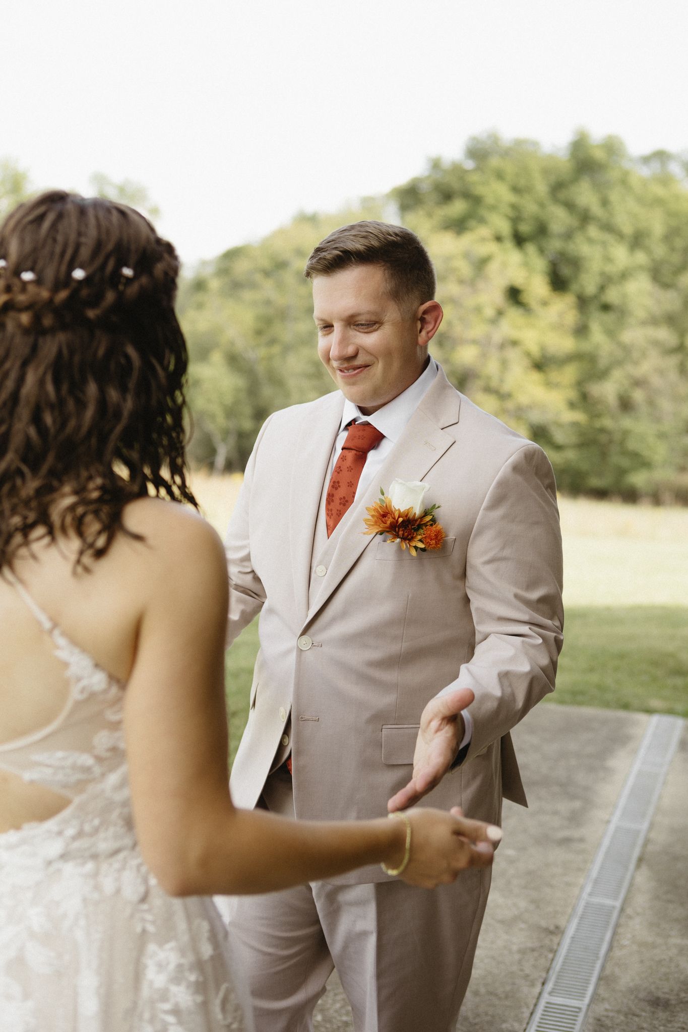 A first look wedding moment captured in a sequence showing the bride and groom meeting in an outdoor garden setting.