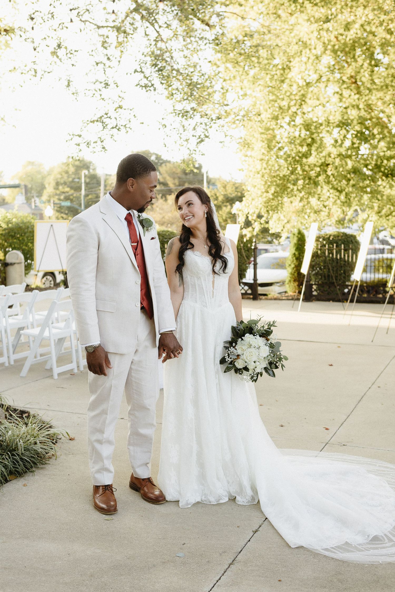Romantic outdoor wedding portraits with golden sunlight filtering through trees.