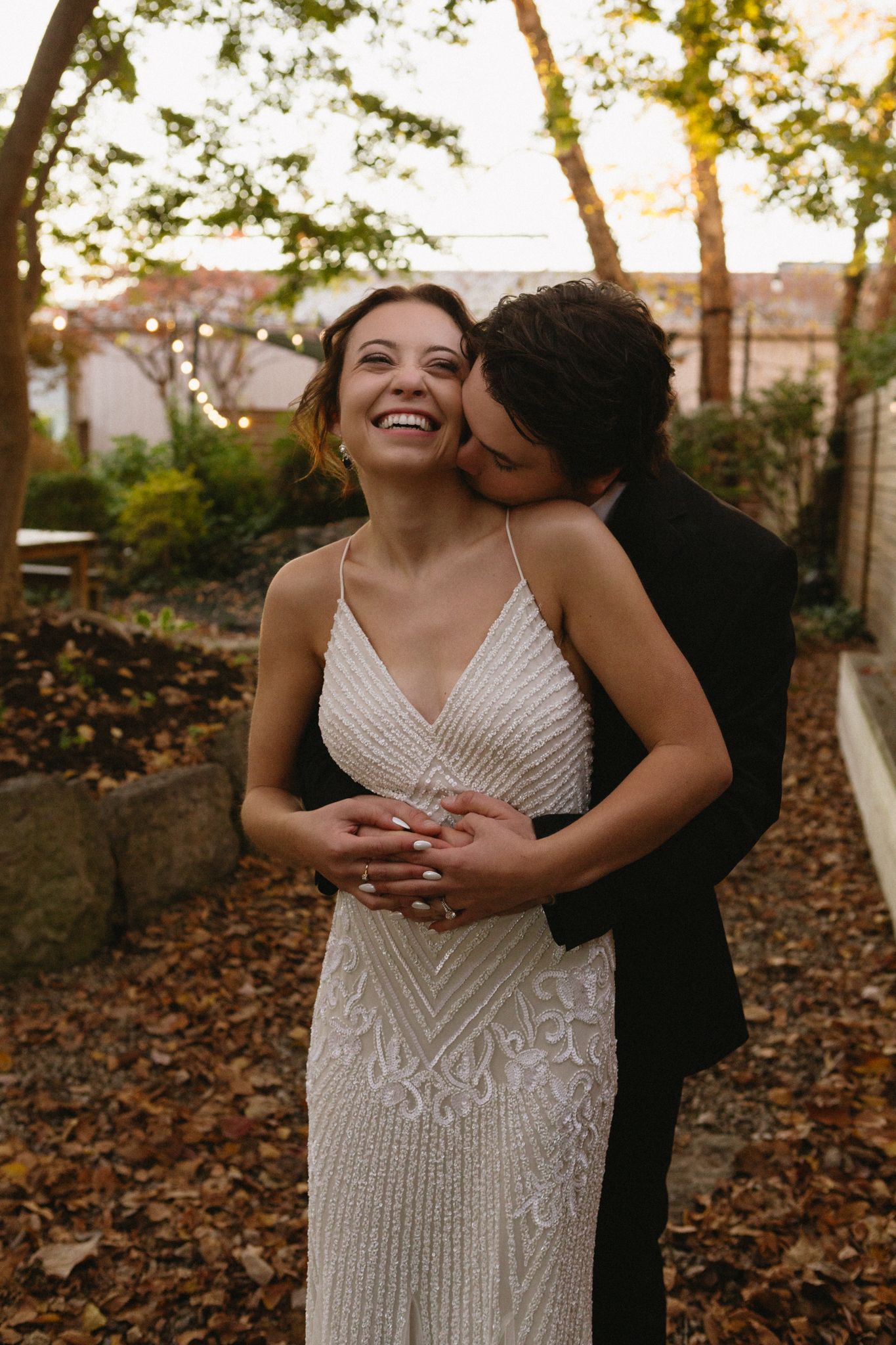 A tender moment between newlyweds laughing together during golden hour.