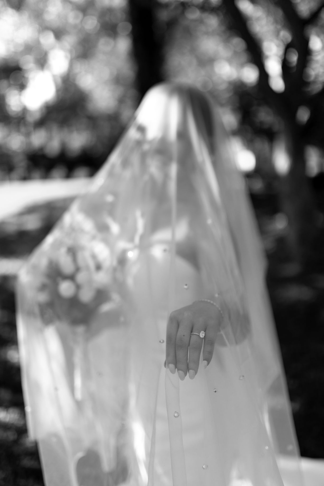 Elegant black and white photo showcasing a bride's delicate ring, symbolizing grace and timeless beauty on her special