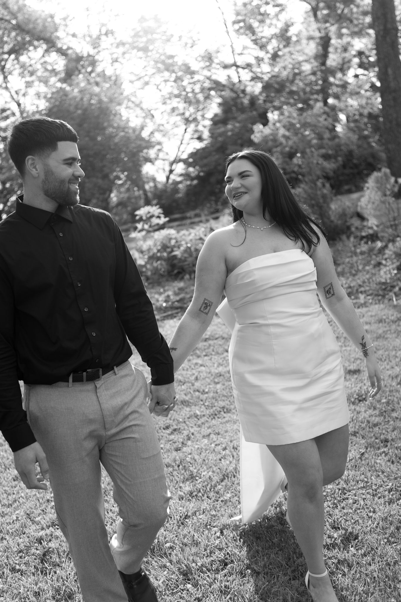 Romantic wedding couple embraces against rustic wooden wall with floral bouquet.