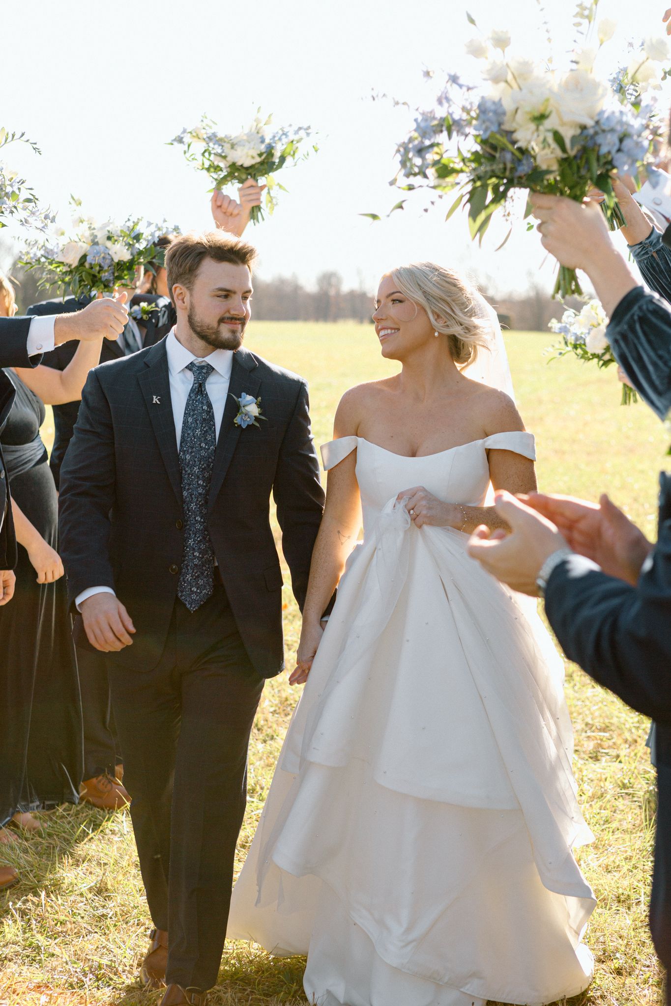 Bride and groom posing with a lush bouquet against a rustic backdrop at Silo Farms. Photo by Joia Lyn, KY wedding photog