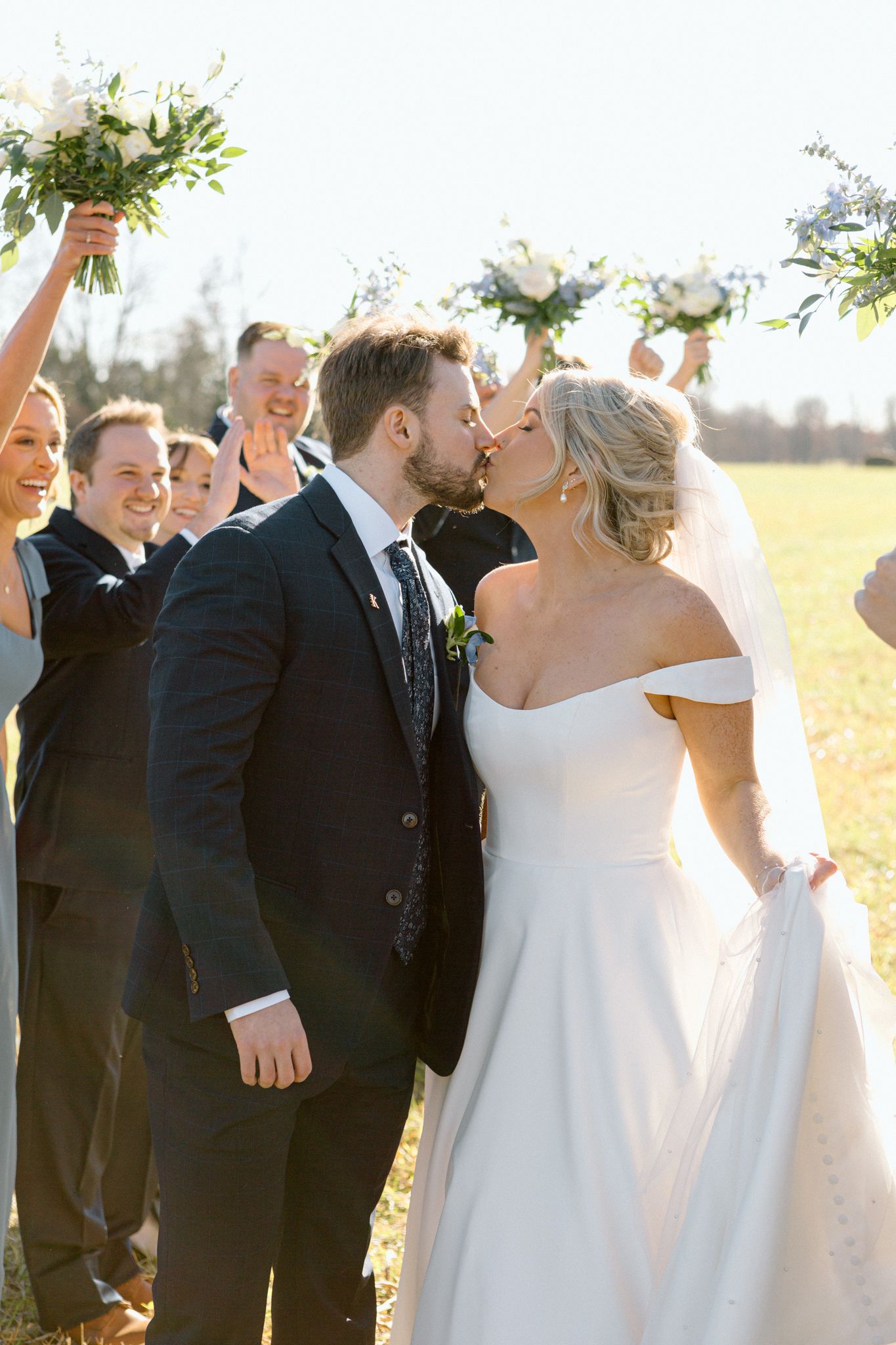 Bride and groom posing with a lush bouquet against a rustic backdrop at Silo Farms. Photo by Joia Lyn, KY wedding photog