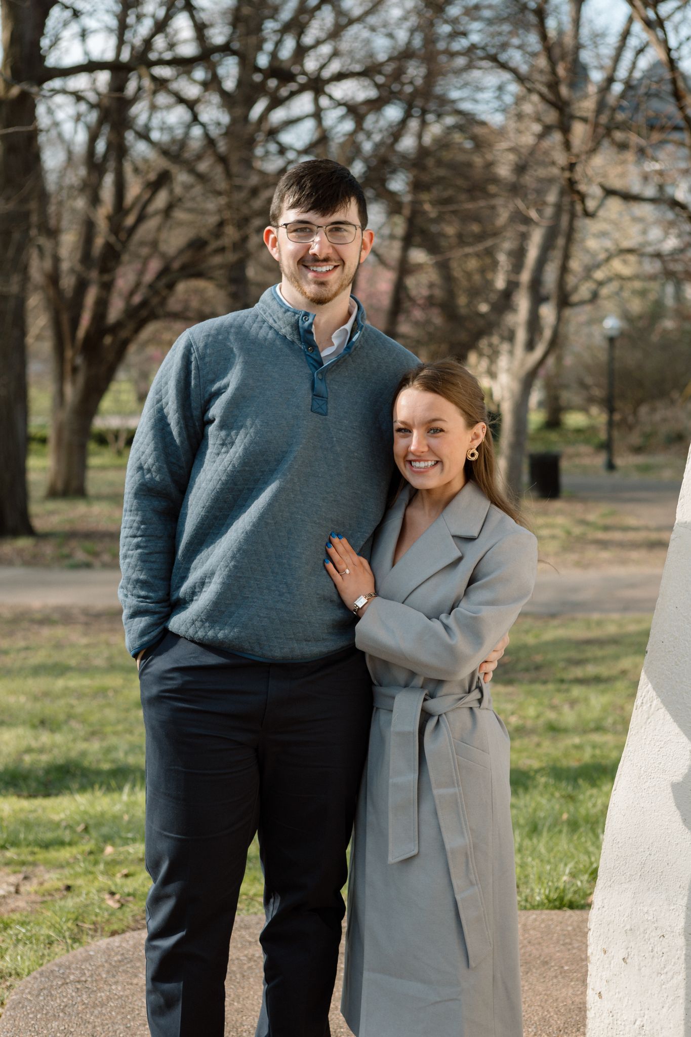 Chilly day engagement shoot in Old Louisville with couple embracing near iconic Victorian architecture.