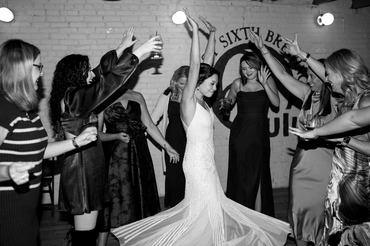 Celebratory group forms a circle on the dance floor at a formal event.