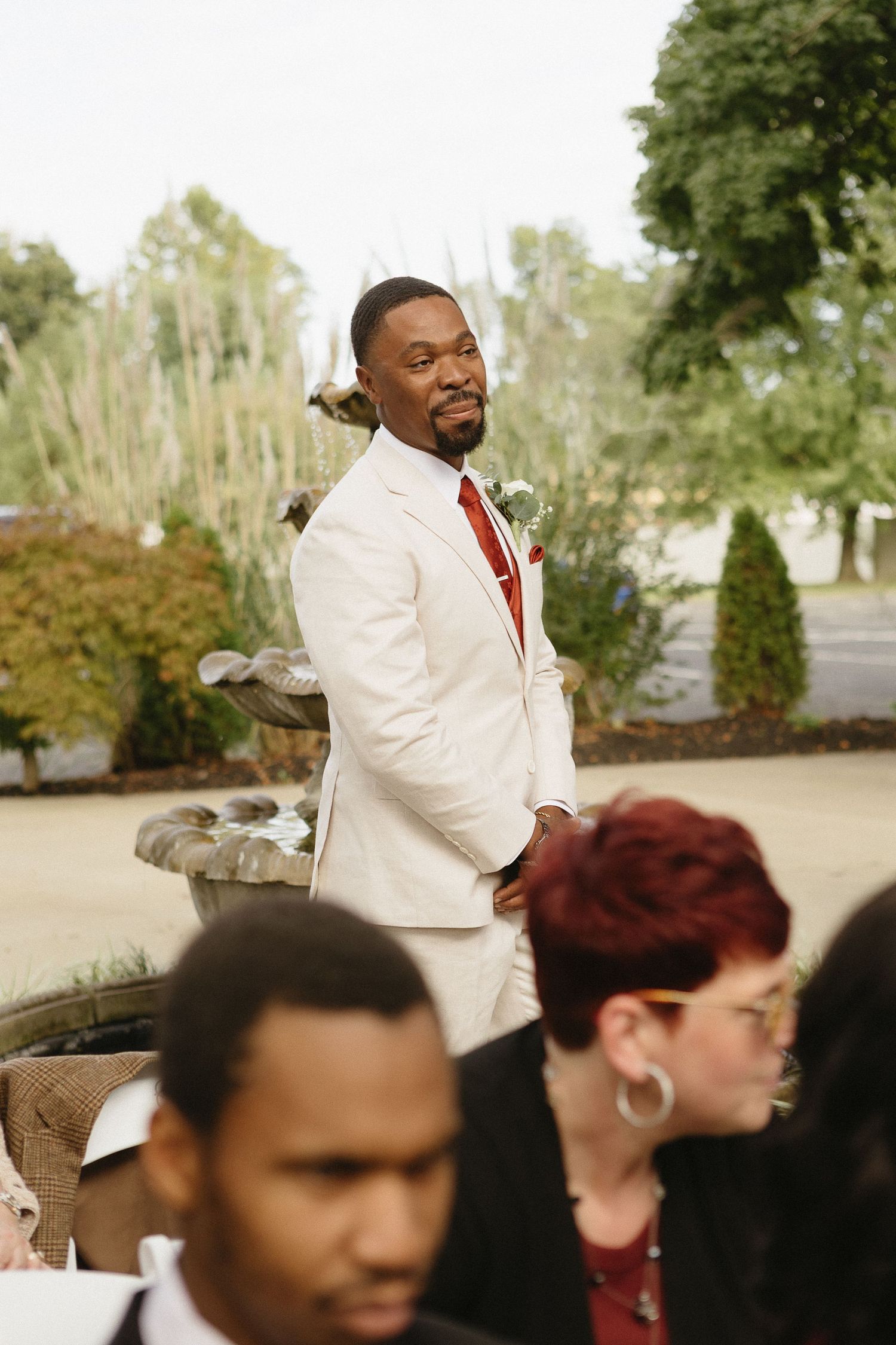 Wedding guests and bridal party members mingle during an outdoor celebration.