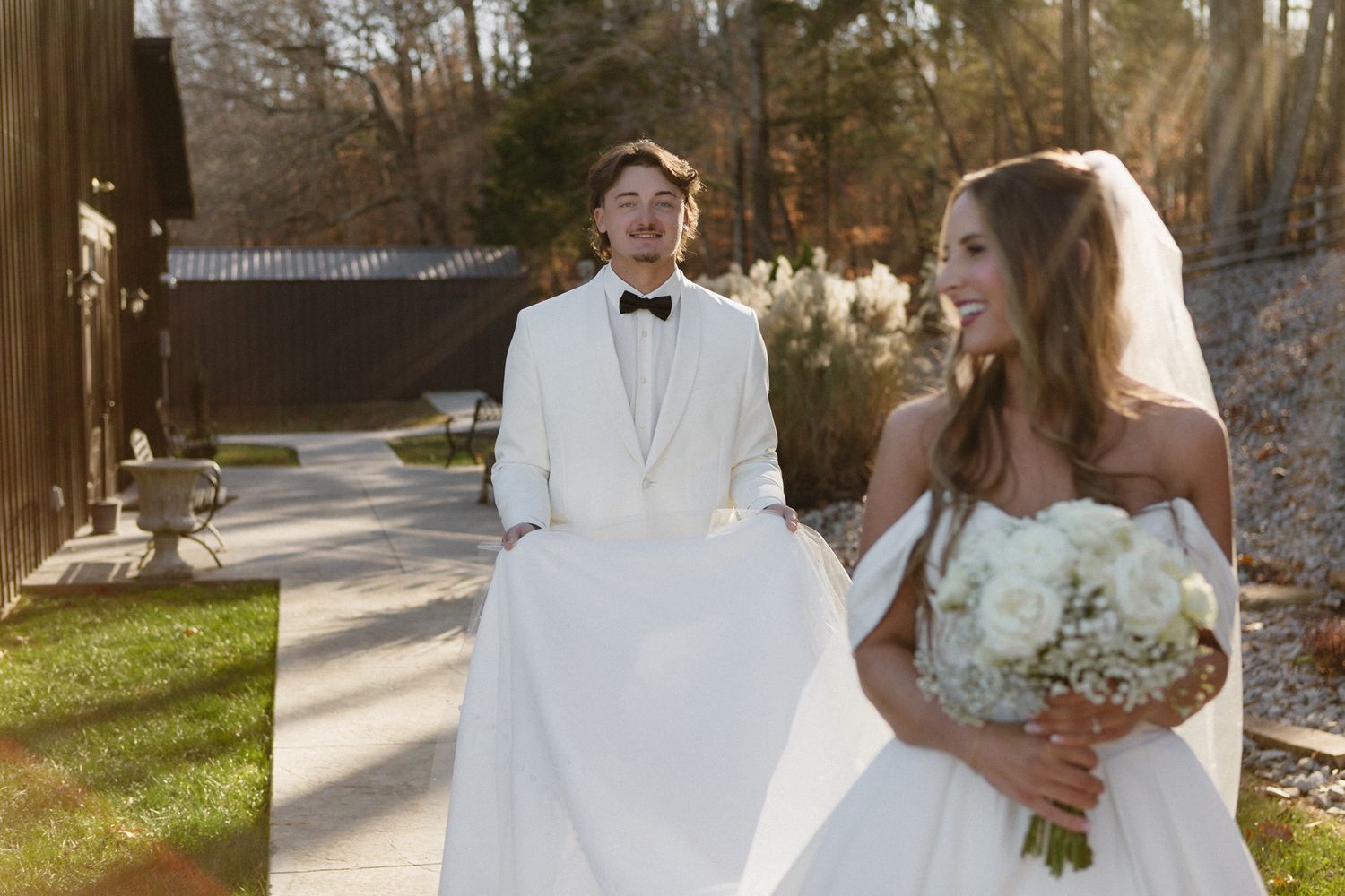 Wedding party poses together outdoors in winter with bridesmaids in black and white floral bouquets.