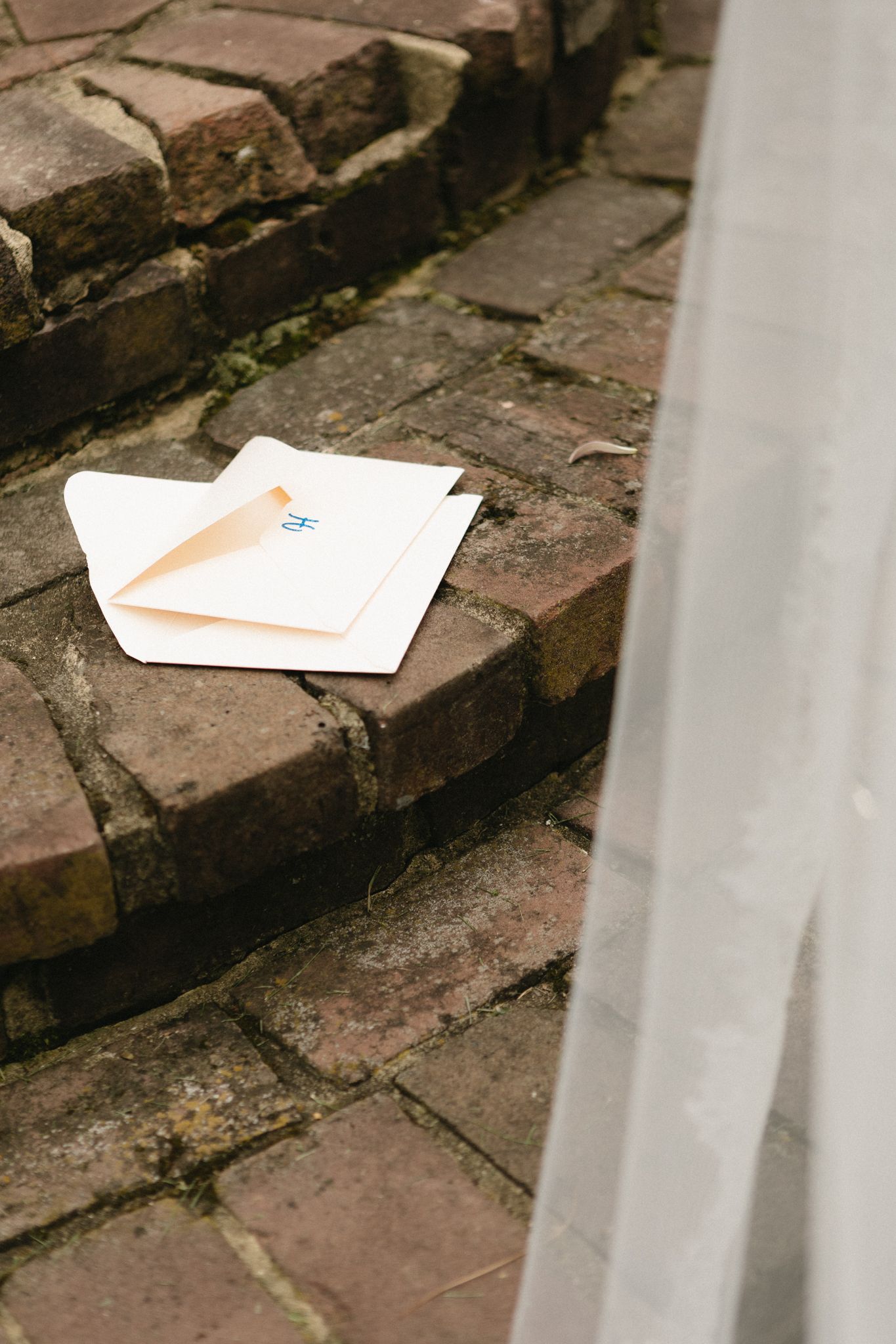 Envelope resting on aged brick steps with white railings.