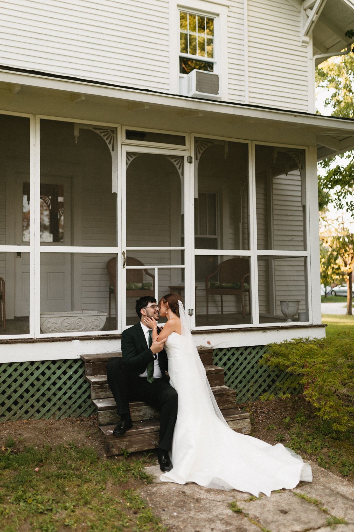 bride and groom walking holding hands kissing during golden hour in backyard wedding venue
