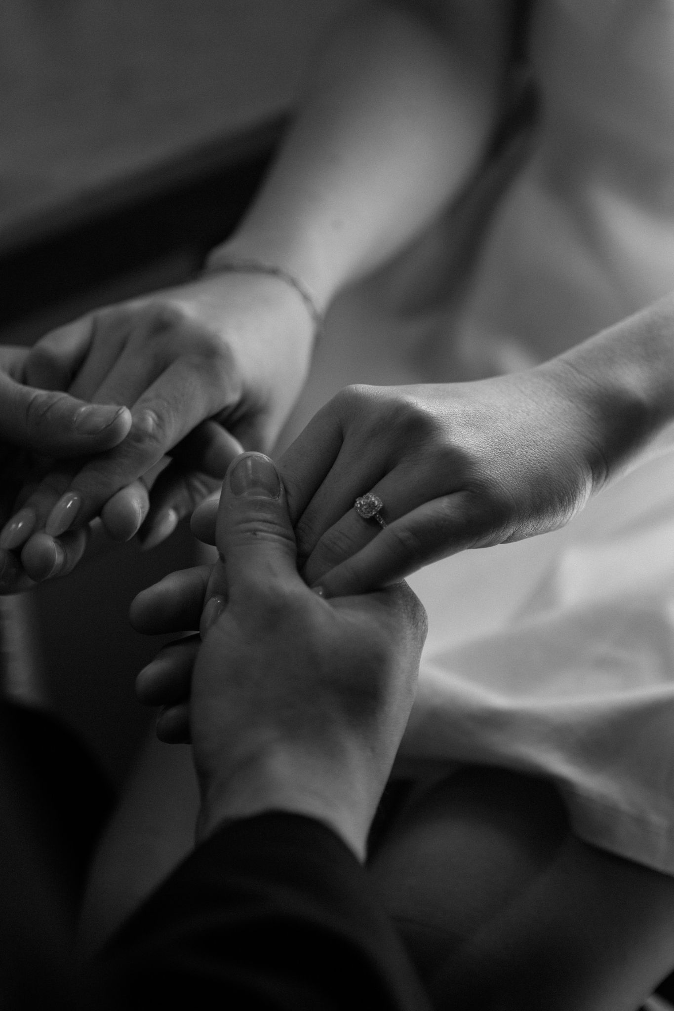 Engaged couple, with the woman showing her engagement ring, captured in downtown Louisville