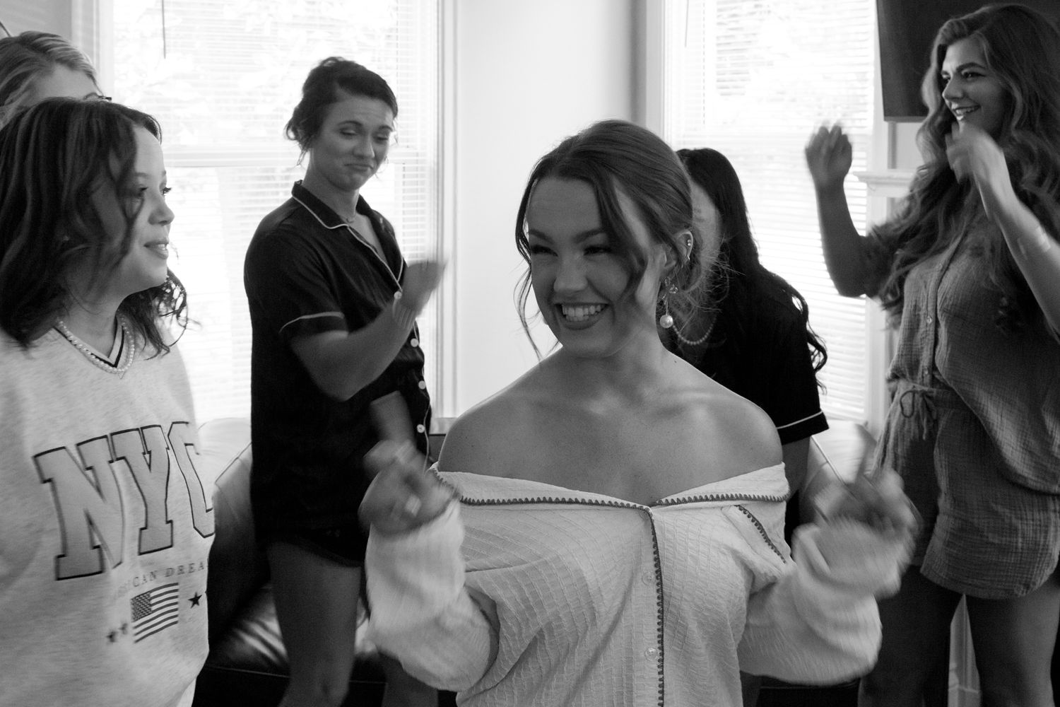 A woman joyfully dances with her friends in a lively room, celebrating friendship and movement together