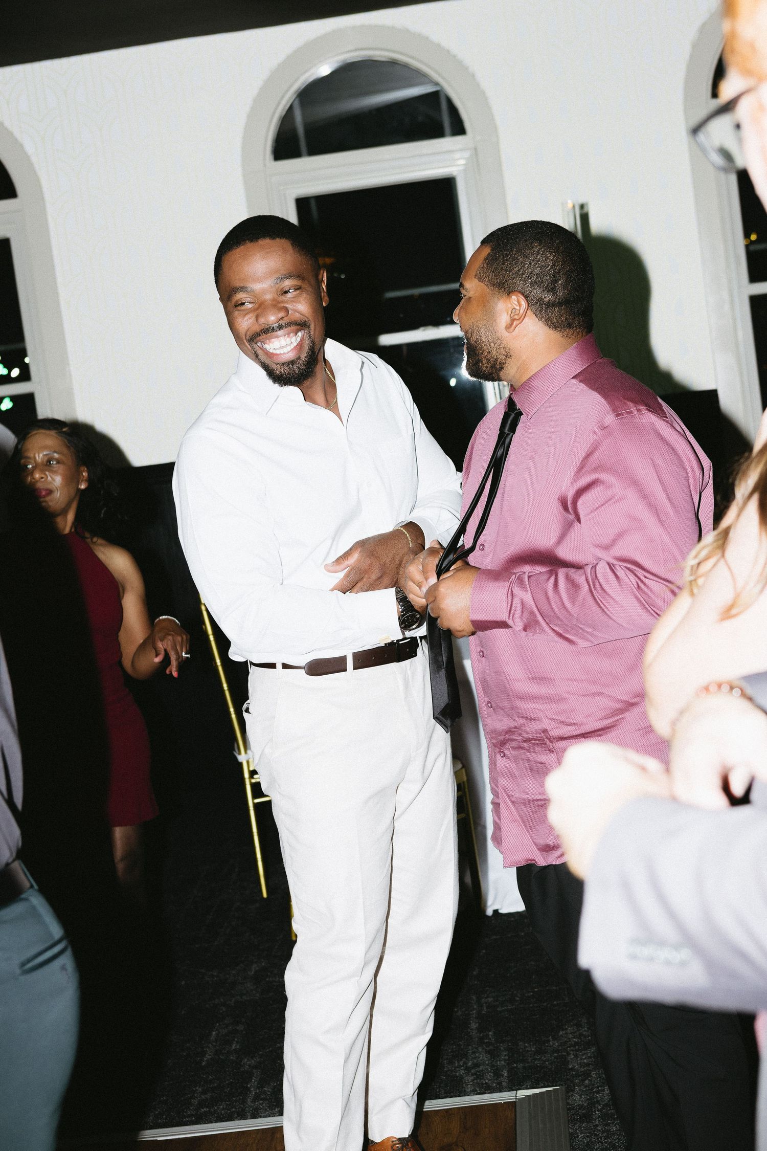 Wedding reception guests dancing and celebrating in formal attire.