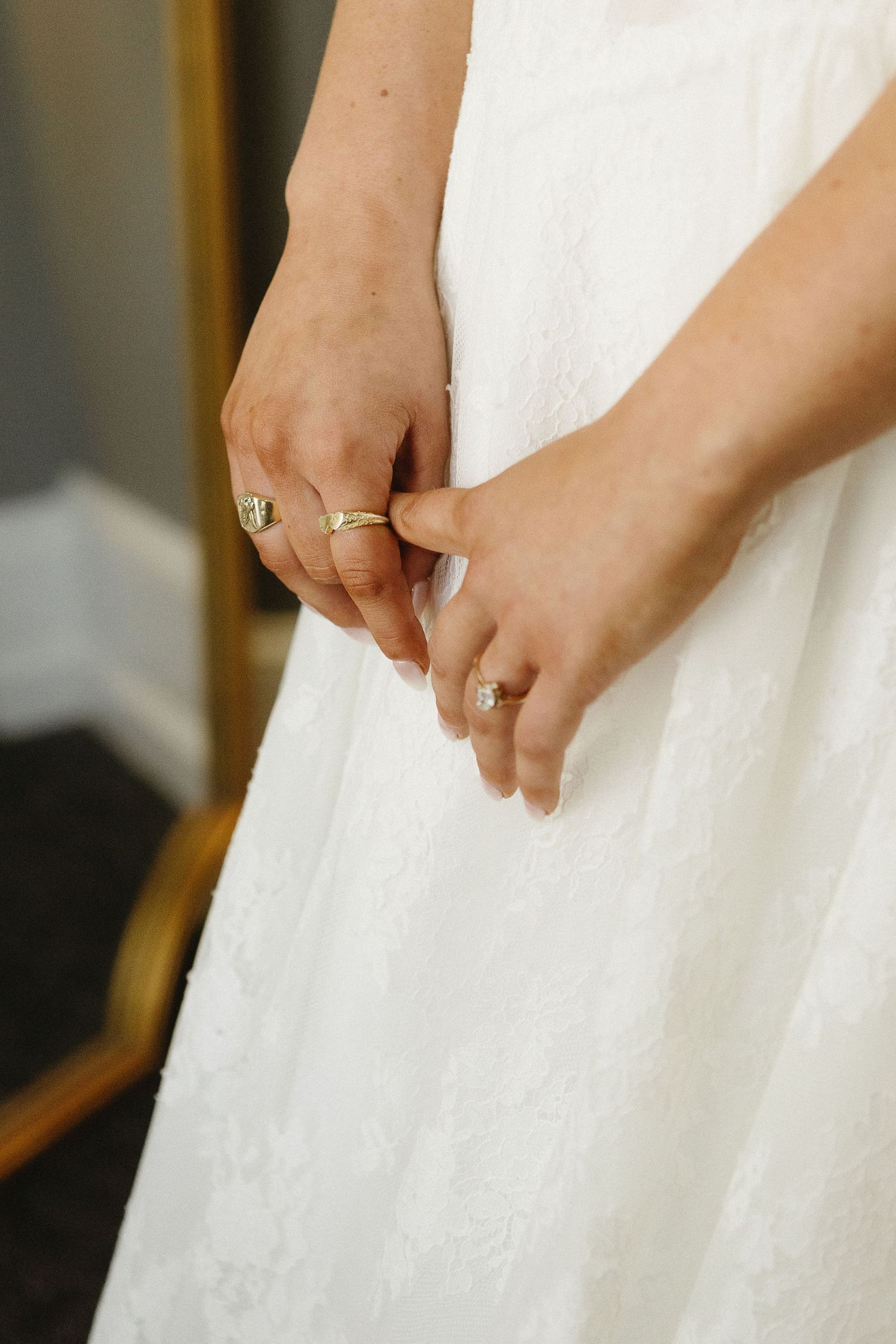 Close-up details of a white wedding dress showing delicate lace patterns and fabric textures.