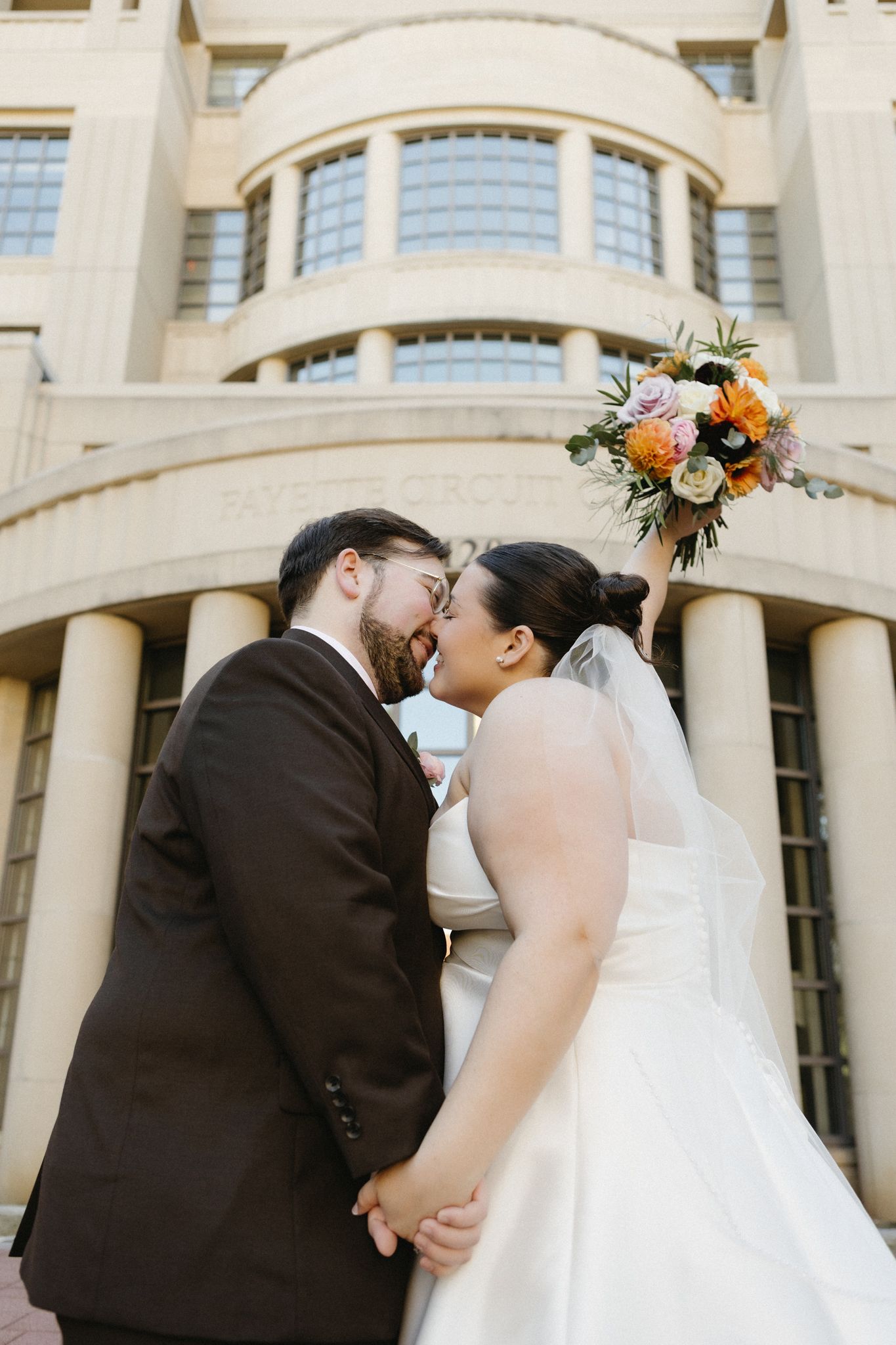 A series of wedding photos showing a couple embracing in front of an elegant architectural backdrop.