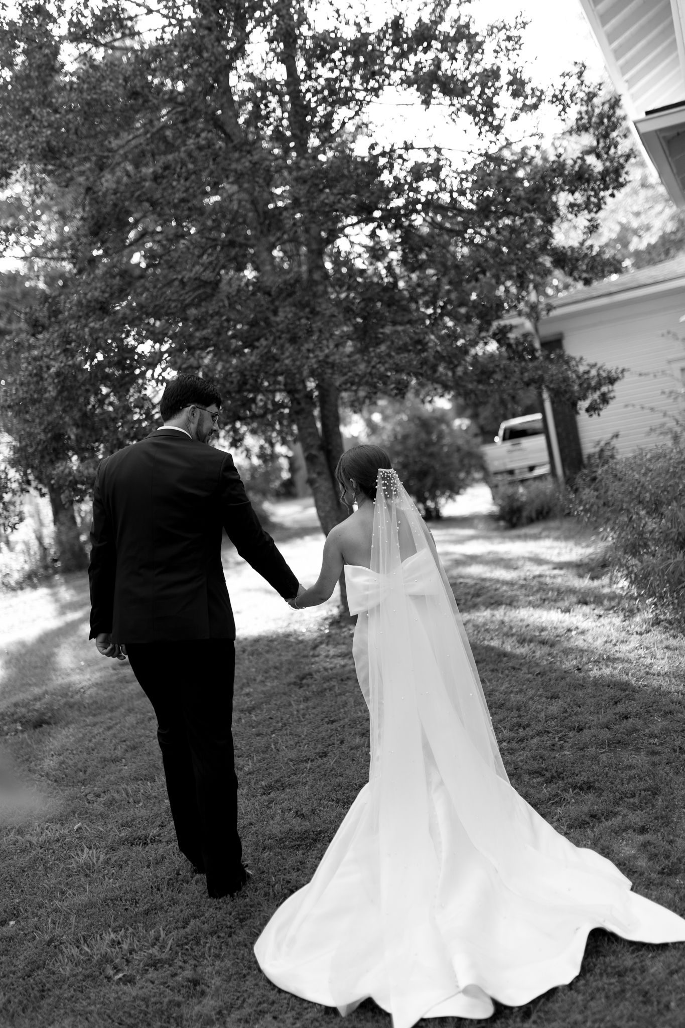 bride and groom walking holding hands during golden hour in backyard wedding venue