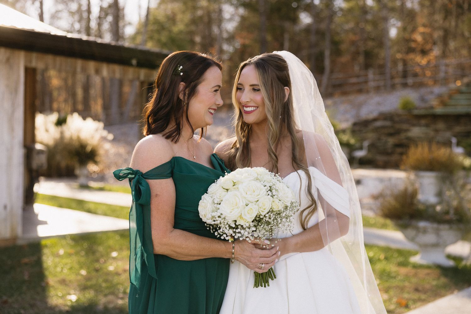 Wedding party celebrates outdoors with white bouquets and elegant formal attire.