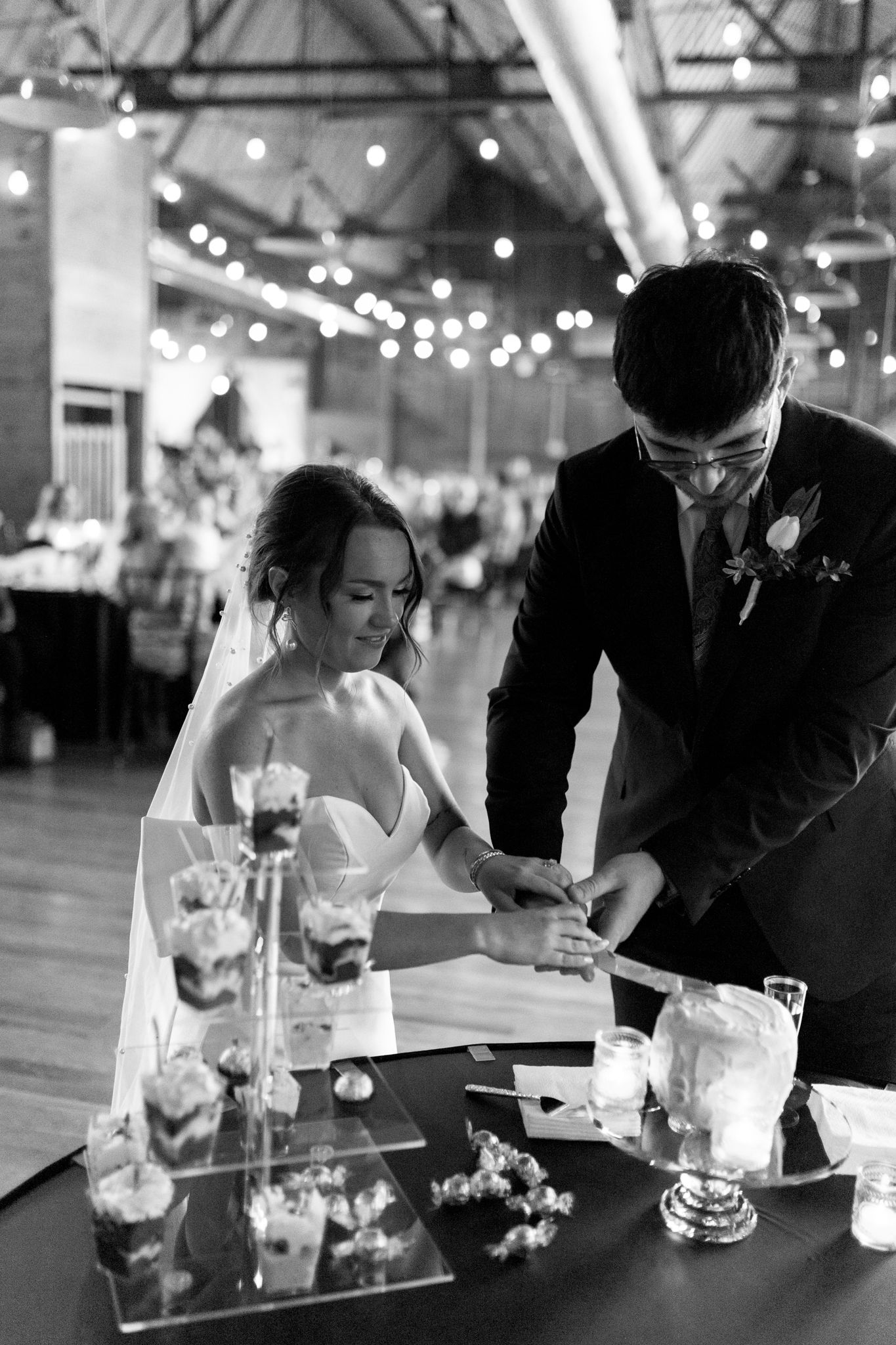 black and white photo couple cutting small wedding cake