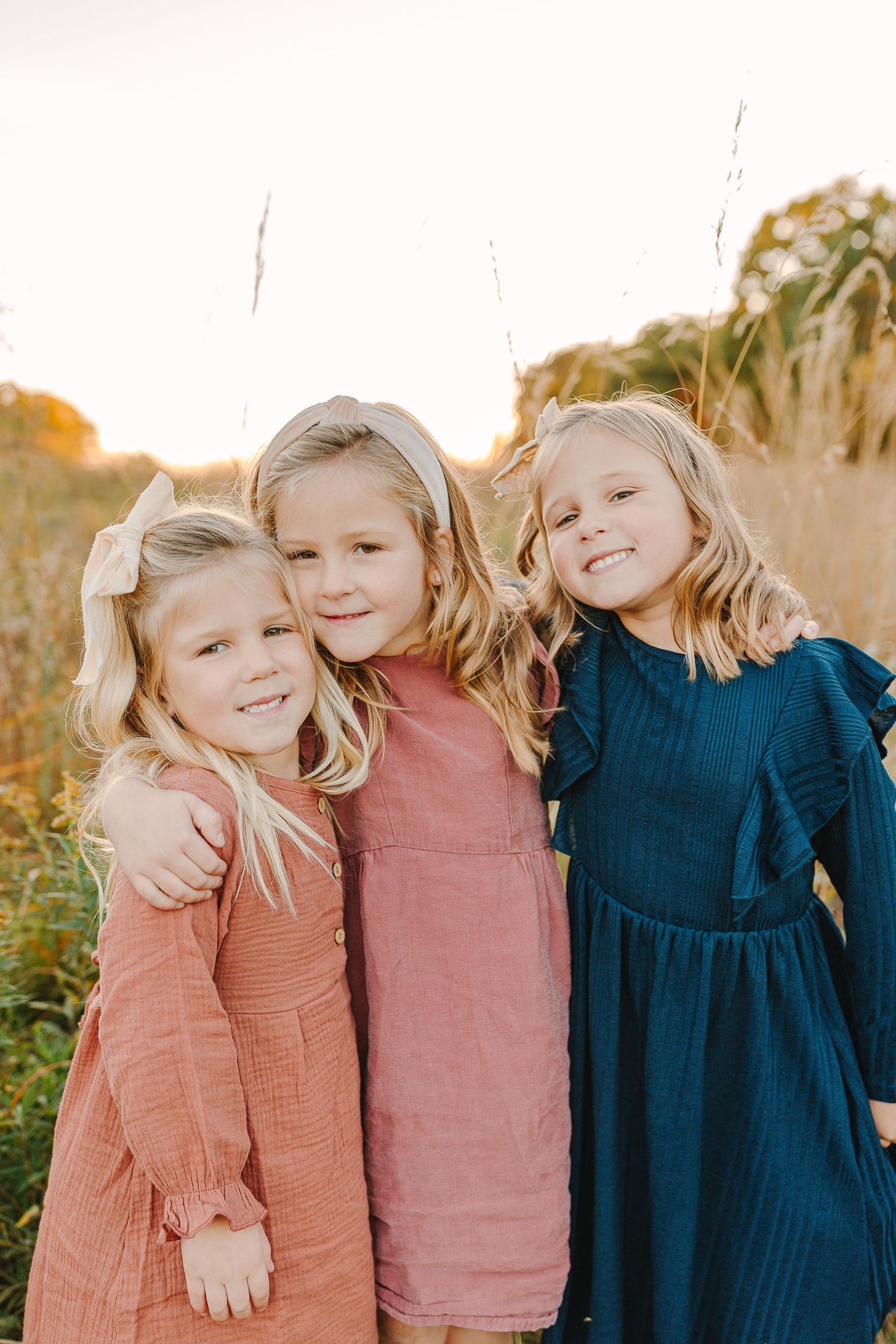 Family in a grassy field at sunset.