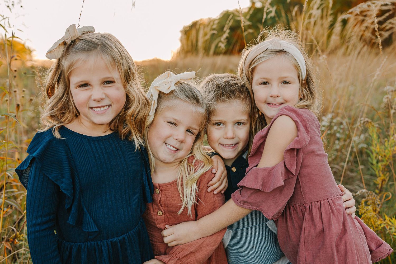 Family in a grassy field at sunset.
