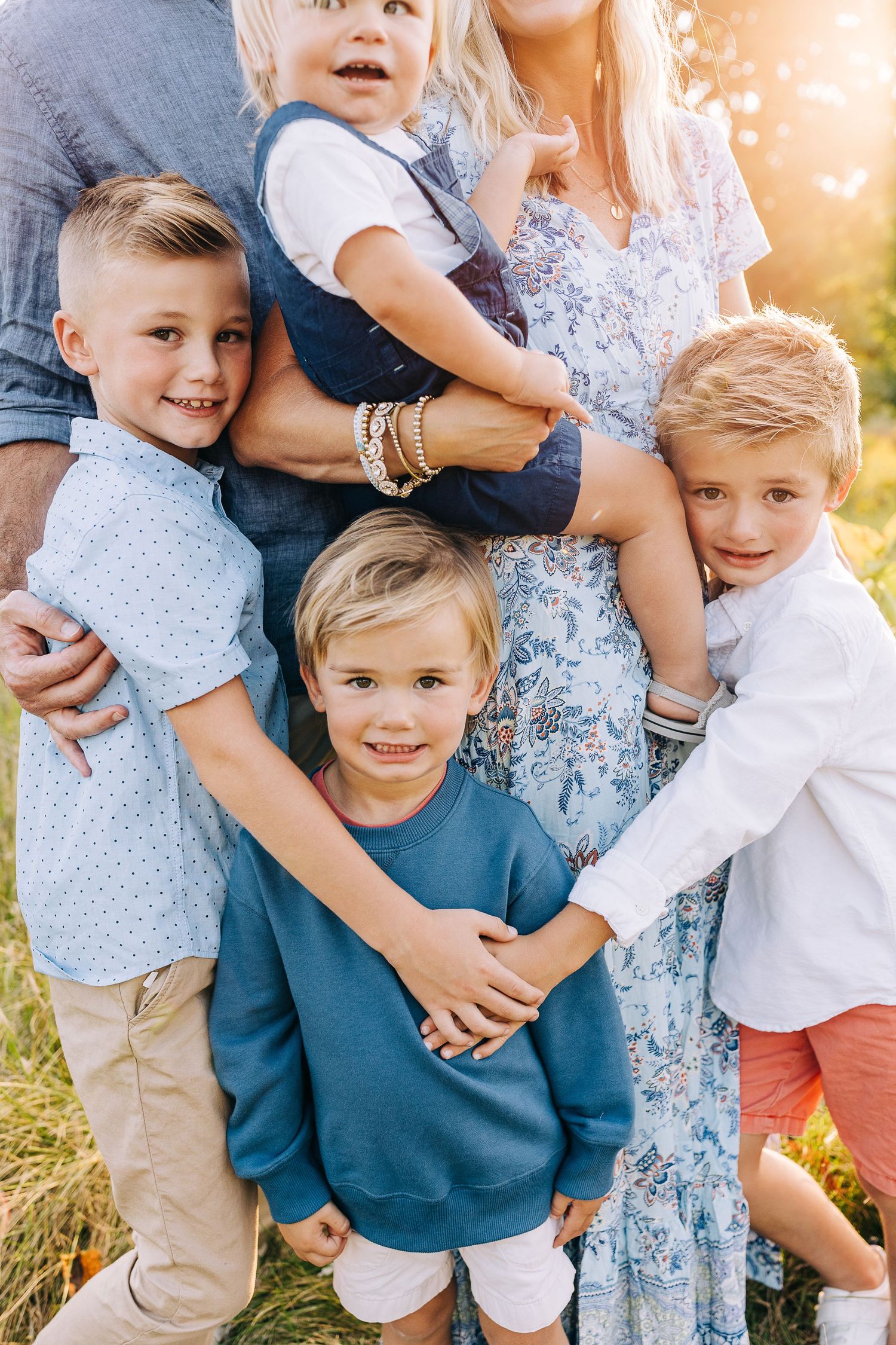 Family portrait in a grassy field at sunset.