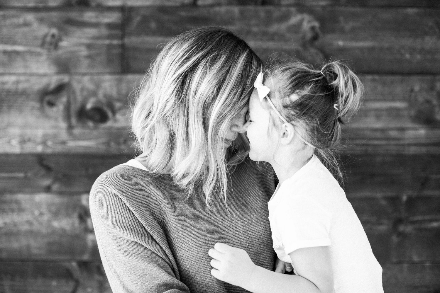 Mother and daughter sharing a sweet moment in a natural light indoor studio.