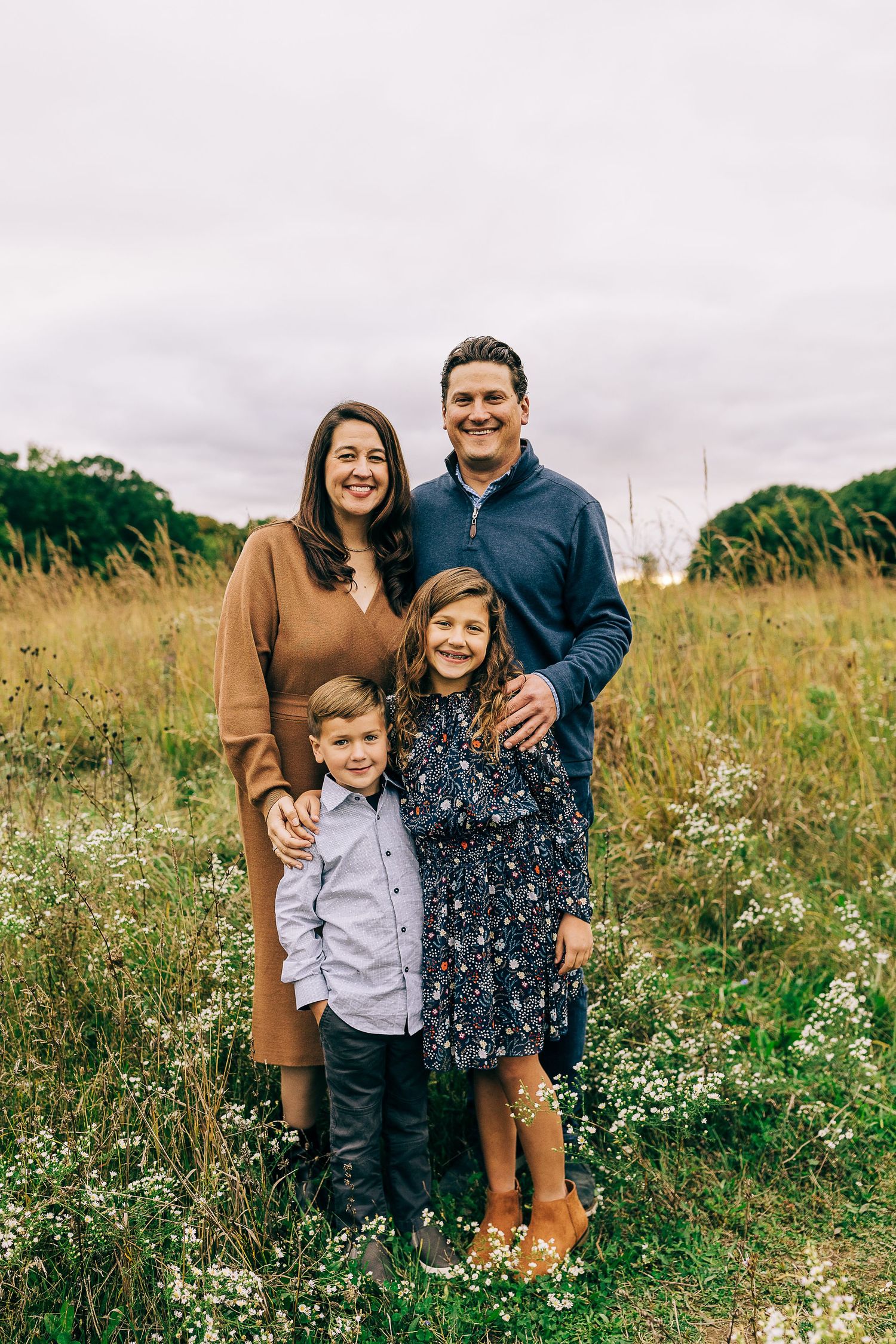 Family in a grassy field at sunset.