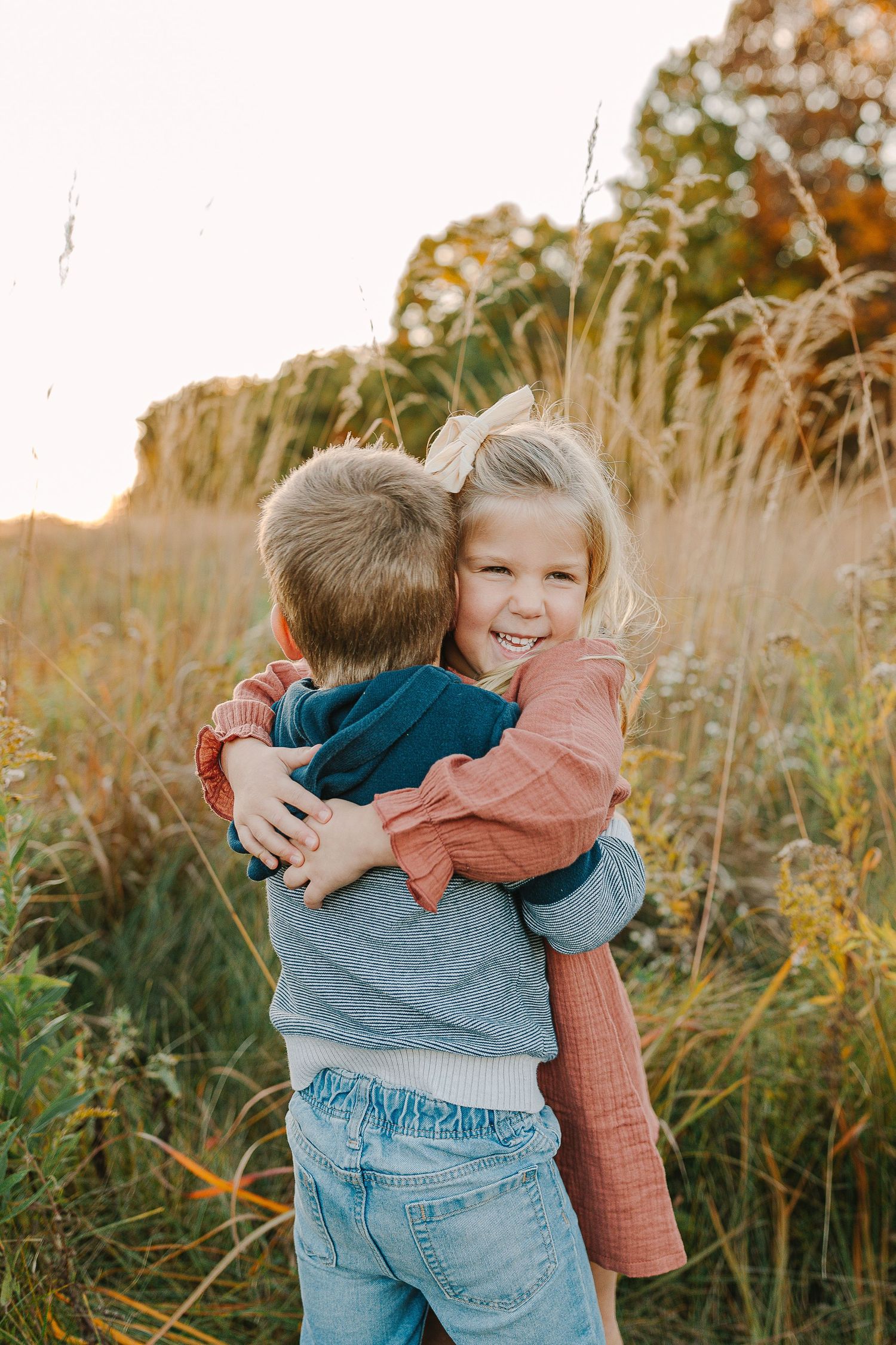Family in a grassy field at sunset.