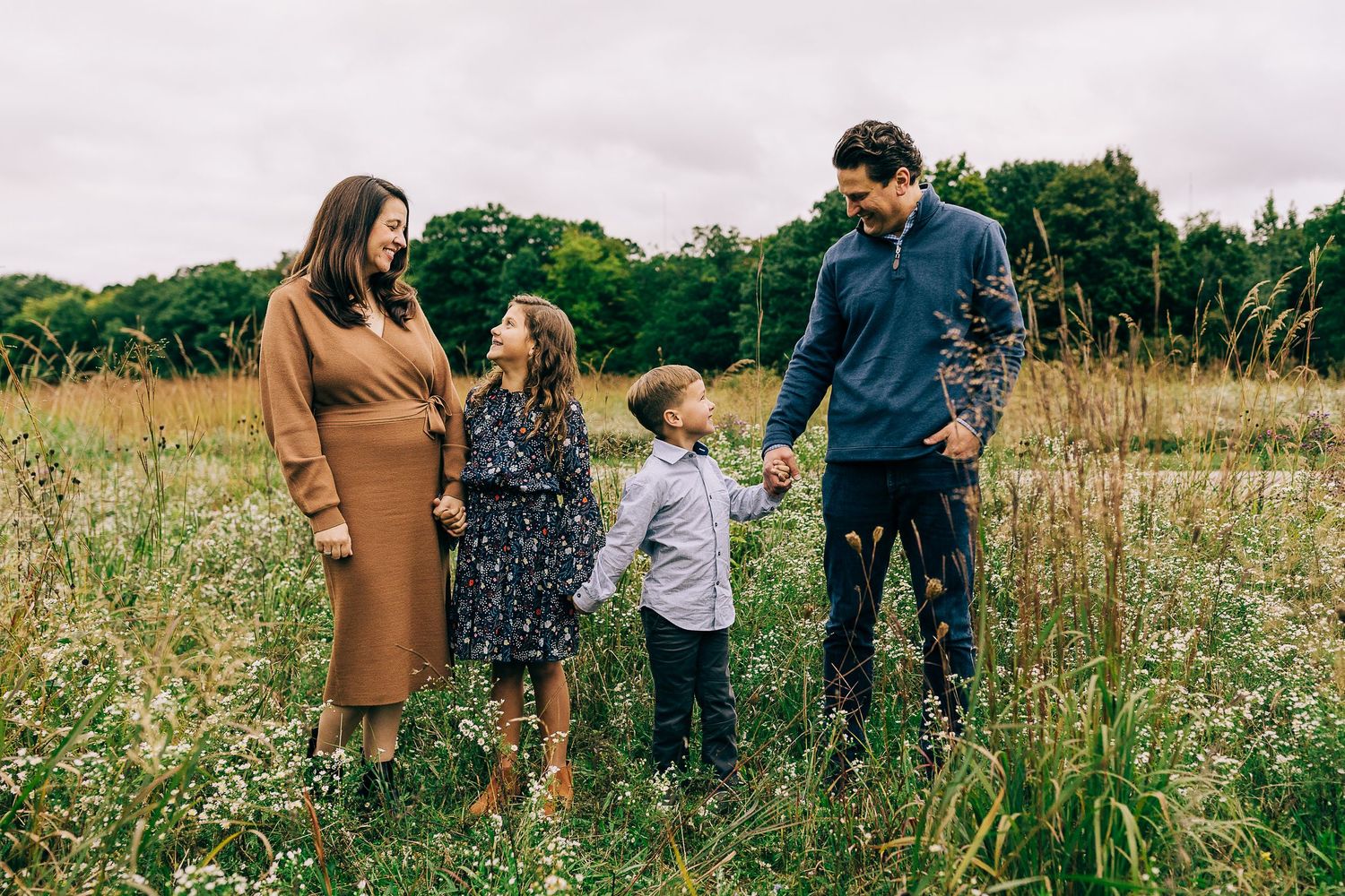 Family in a grassy field at sunset.