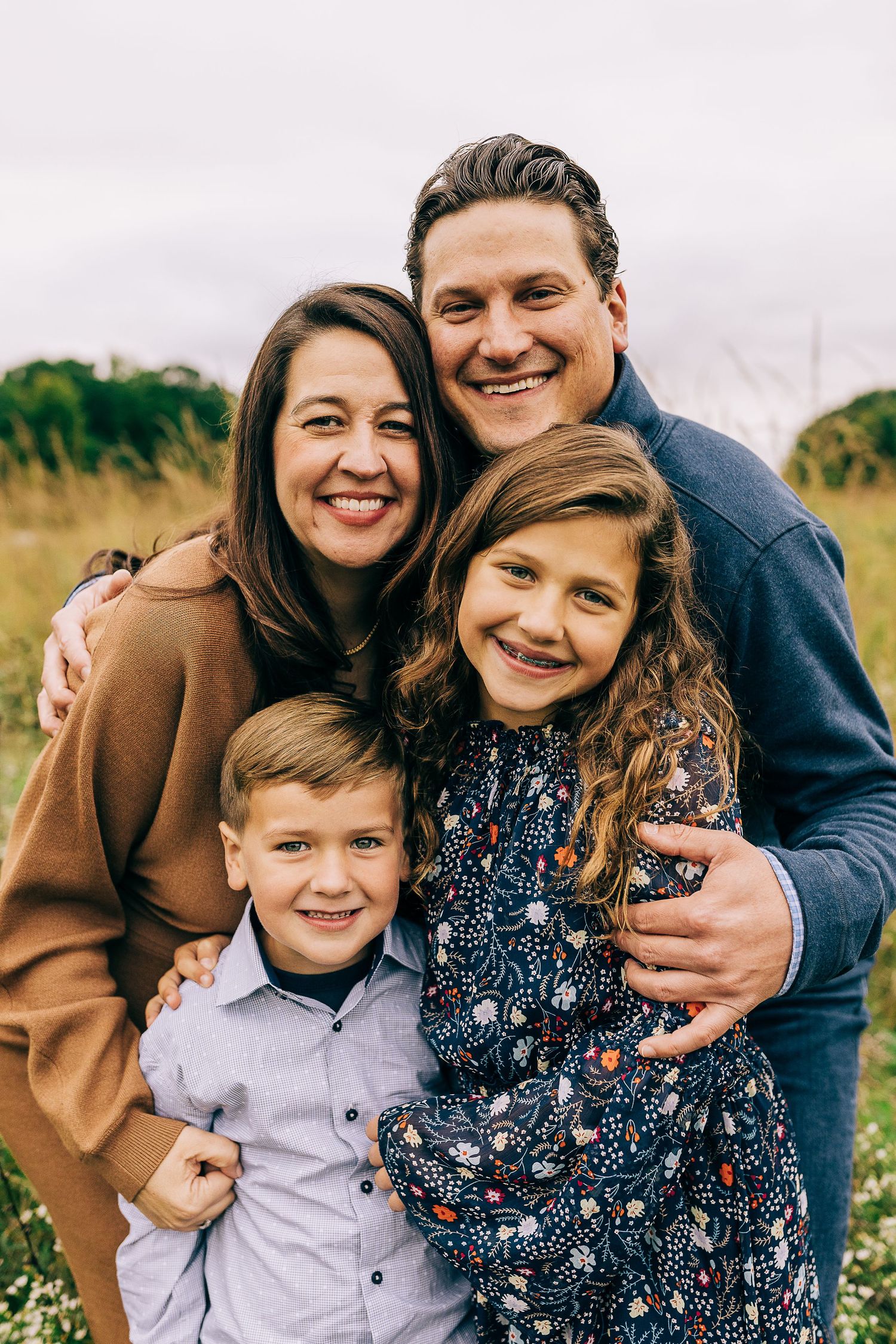 Family in a grassy field at sunset.