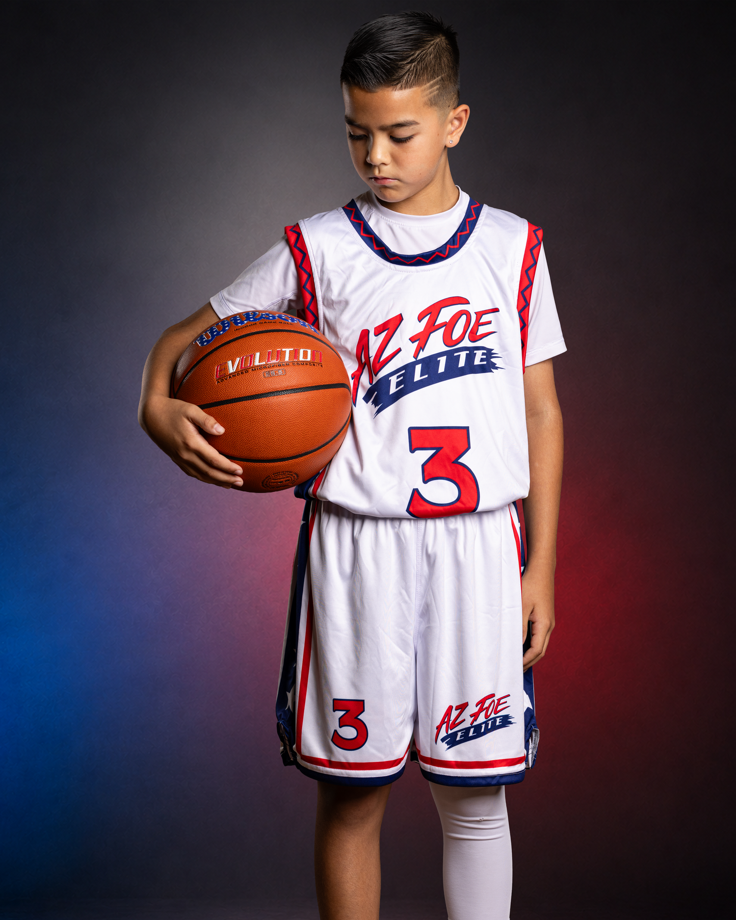 Youth basketball player #3 in AZ Foe Elite white uniform holds ball in dramatic studio portrait photo.