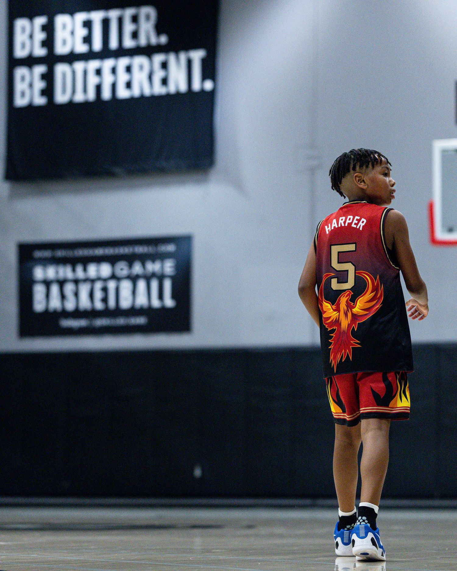 Young basketball player #5 Harper stands on court in black phoenix jersey.