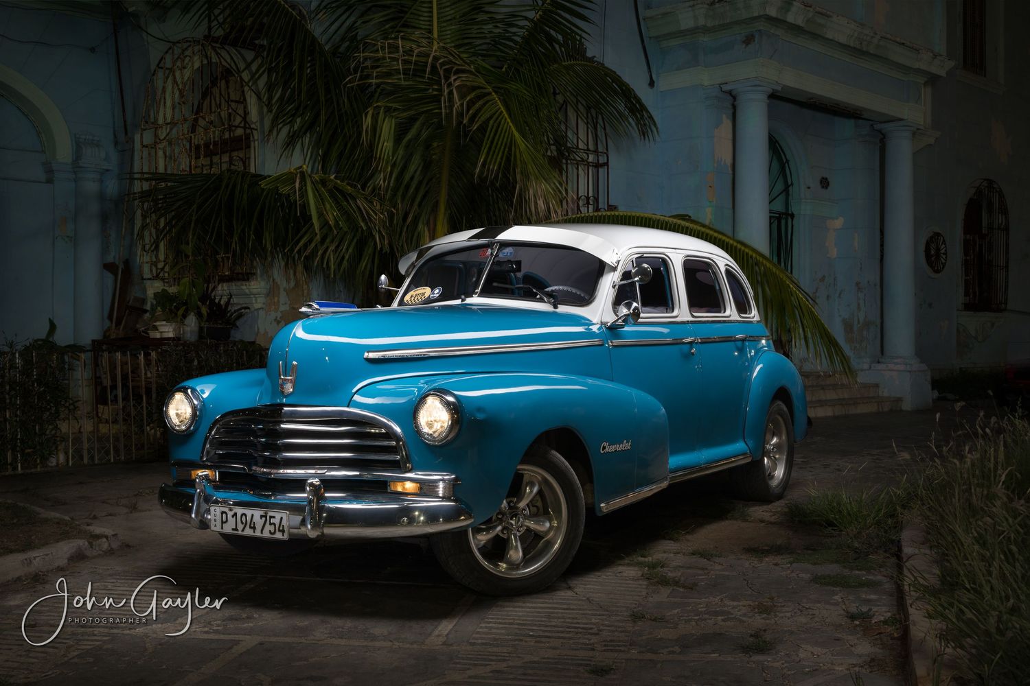 John Gayler light painting fine art wall portrait of 1946 Chevrolet Fleetmaster with blue white paint outside a hacienda in Old Havana Cub