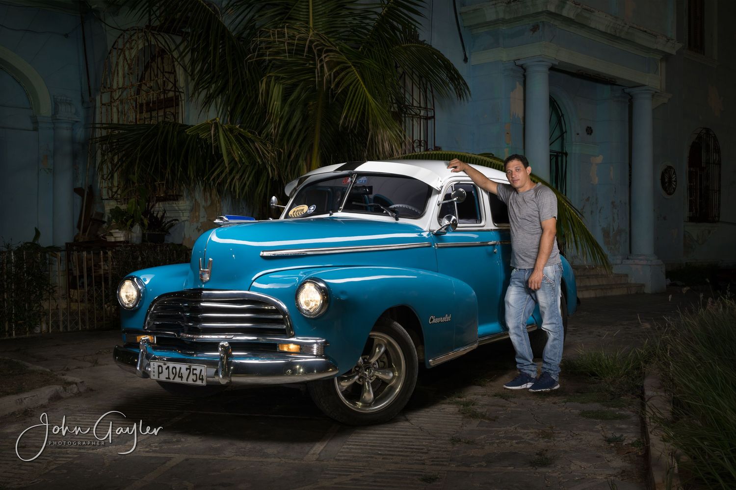 John Gayler light painting fine art wall portrait of 1946 Chevrolet Fleetmaster with taxi driver outside a hacienda in Old Havana Cub
