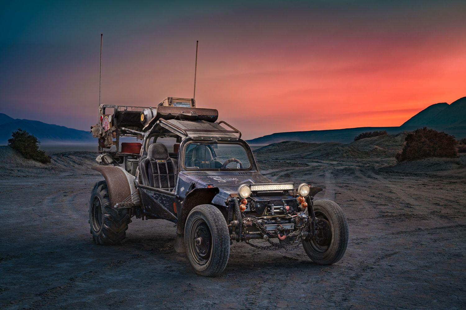 A John Gayler fine art wall portrait of the Mad Max roadster on the Playa at Black Rock Desert 3/4 view with a colorful sunset.