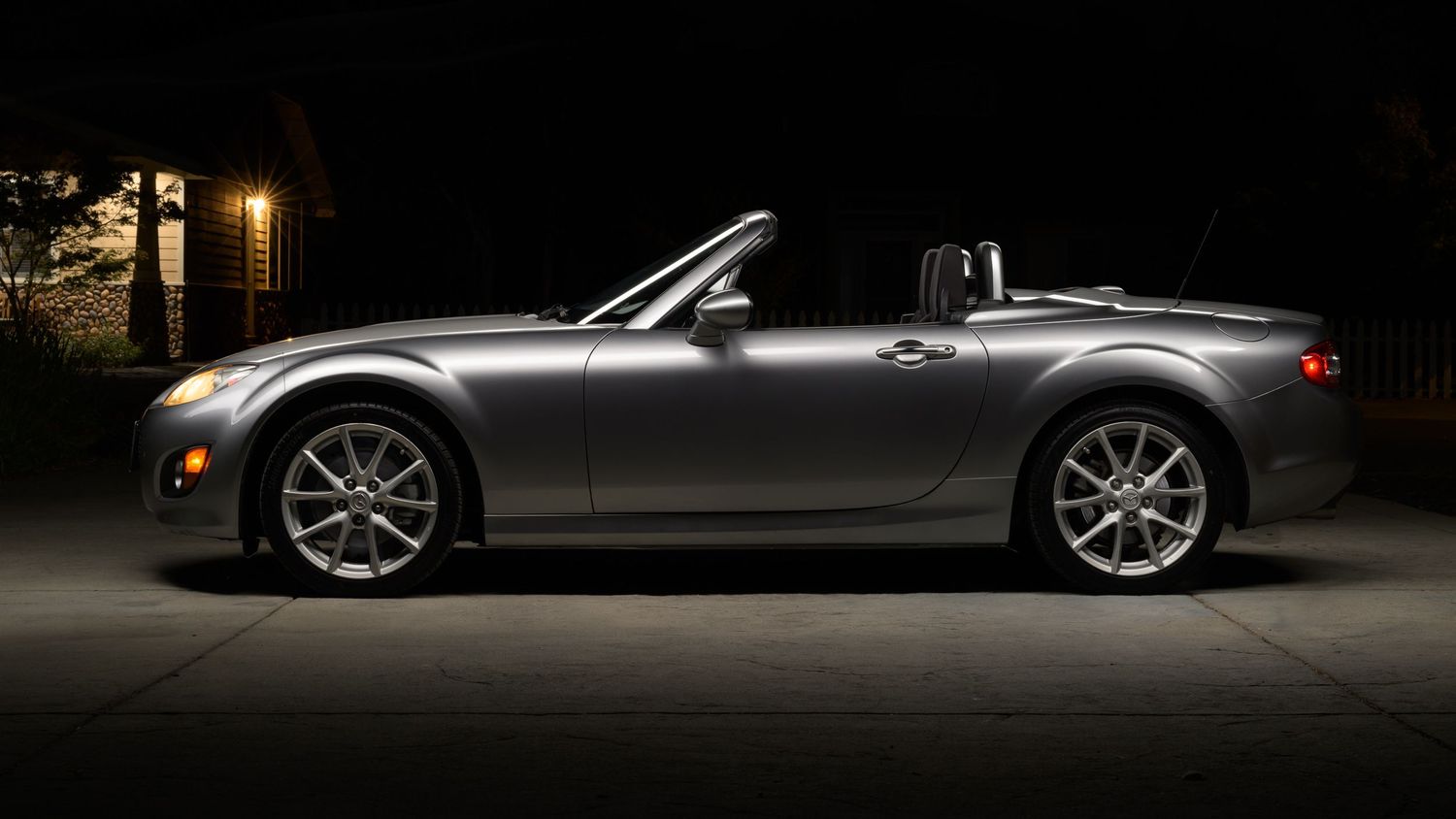 A sleek silver sports car photographed in dramatic low light conditions with multiple side profile views.