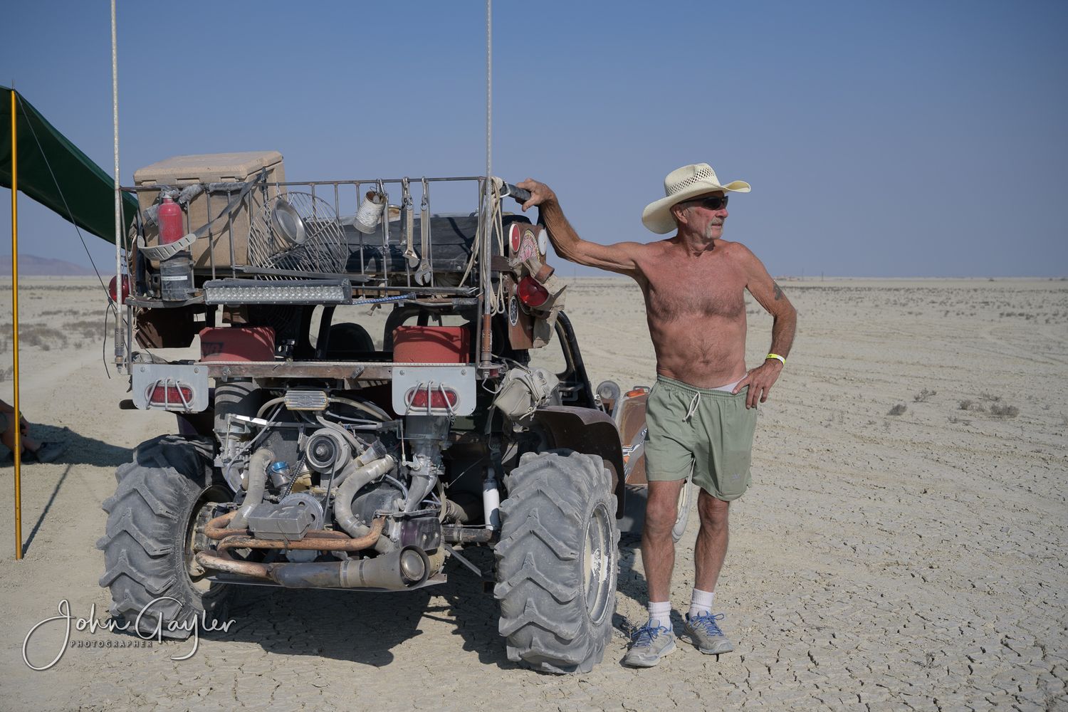 Mad Max, the owner of a custom roadster  poses with his vehicle on the playa at Black Rock Desert, Nevada