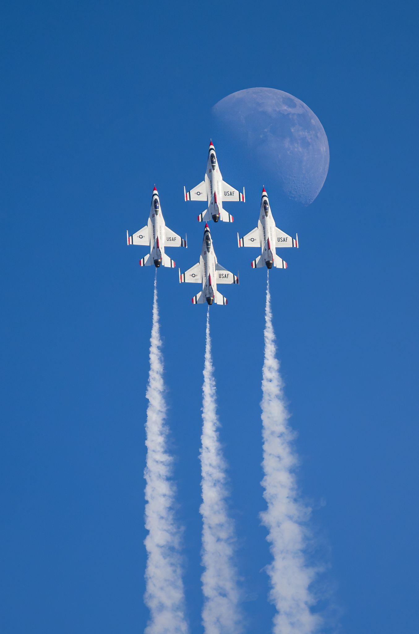 Team USA member John Gayler,  World Photographic Cup finalist image of four Thunderbird jets and their trails soar toward the half moon