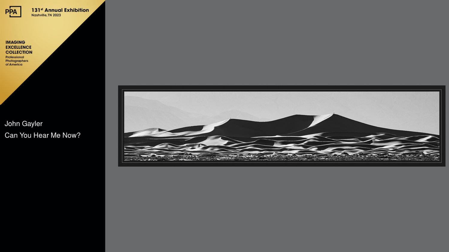 Two people converse across the mesquite dunes in Death Valley . Black and white, panorama