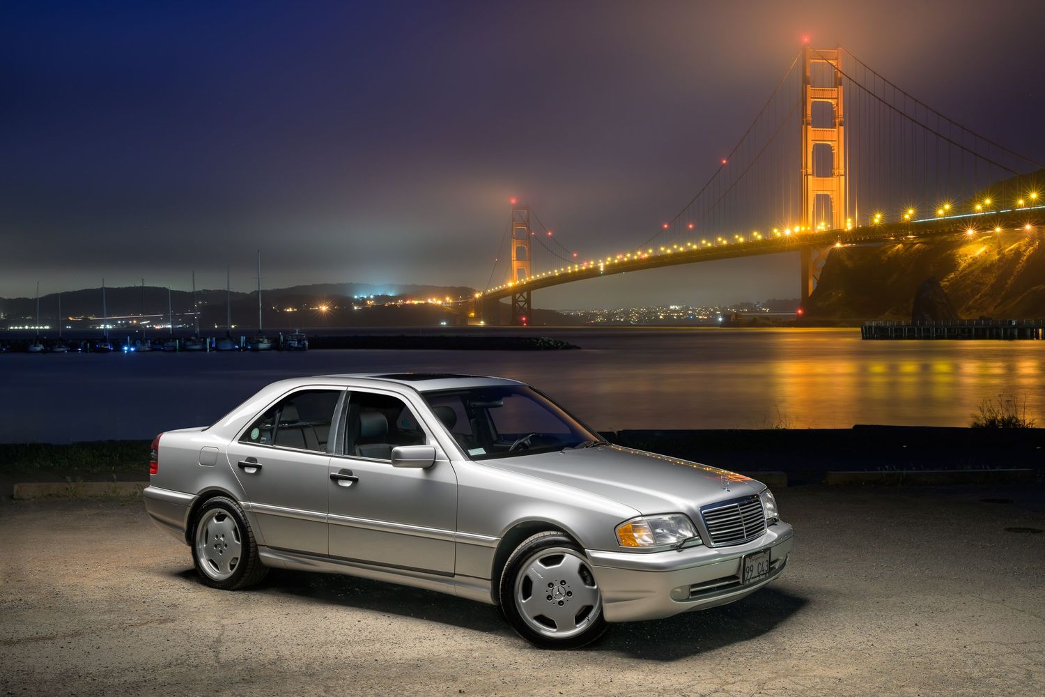 John Gayler Light Painting of a concours winning pristine silver 1999 AMG C43 with illuminated Golden Gate bridge from Horseshoe Bay