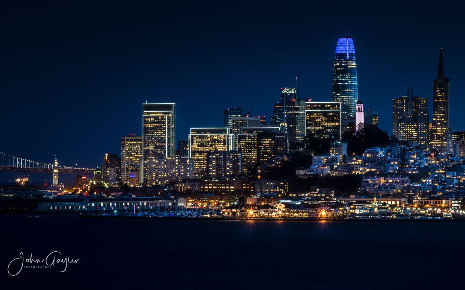 The architecture of San Francisco lit up at night, viewed from Alcatraz Island.
