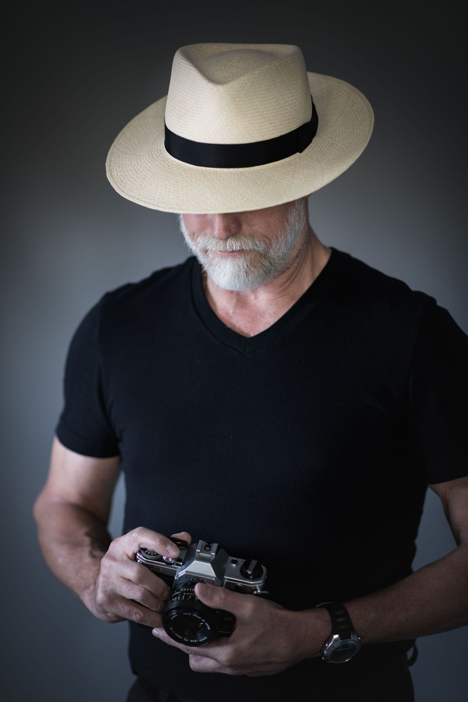 John Gayler featured in a mysterious self-portrait featuring a beautiful Montecristo Panama hat and Canon AE-1 film camera