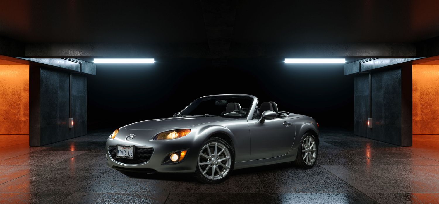 John Gayler Light Painting Panoramic view of luxury sports cars lined up in a dark garage with dramatic lighting and reflective surfaces.