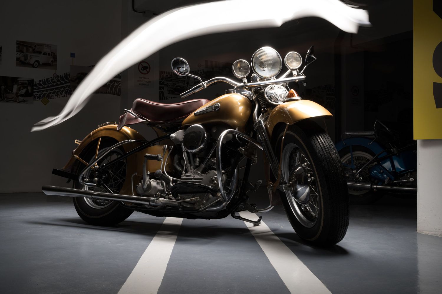 Single shot of classic 1940s Harley Davidson Knucklehead motorcycle with gold paint in a light painting portrait by John Gayler Photography