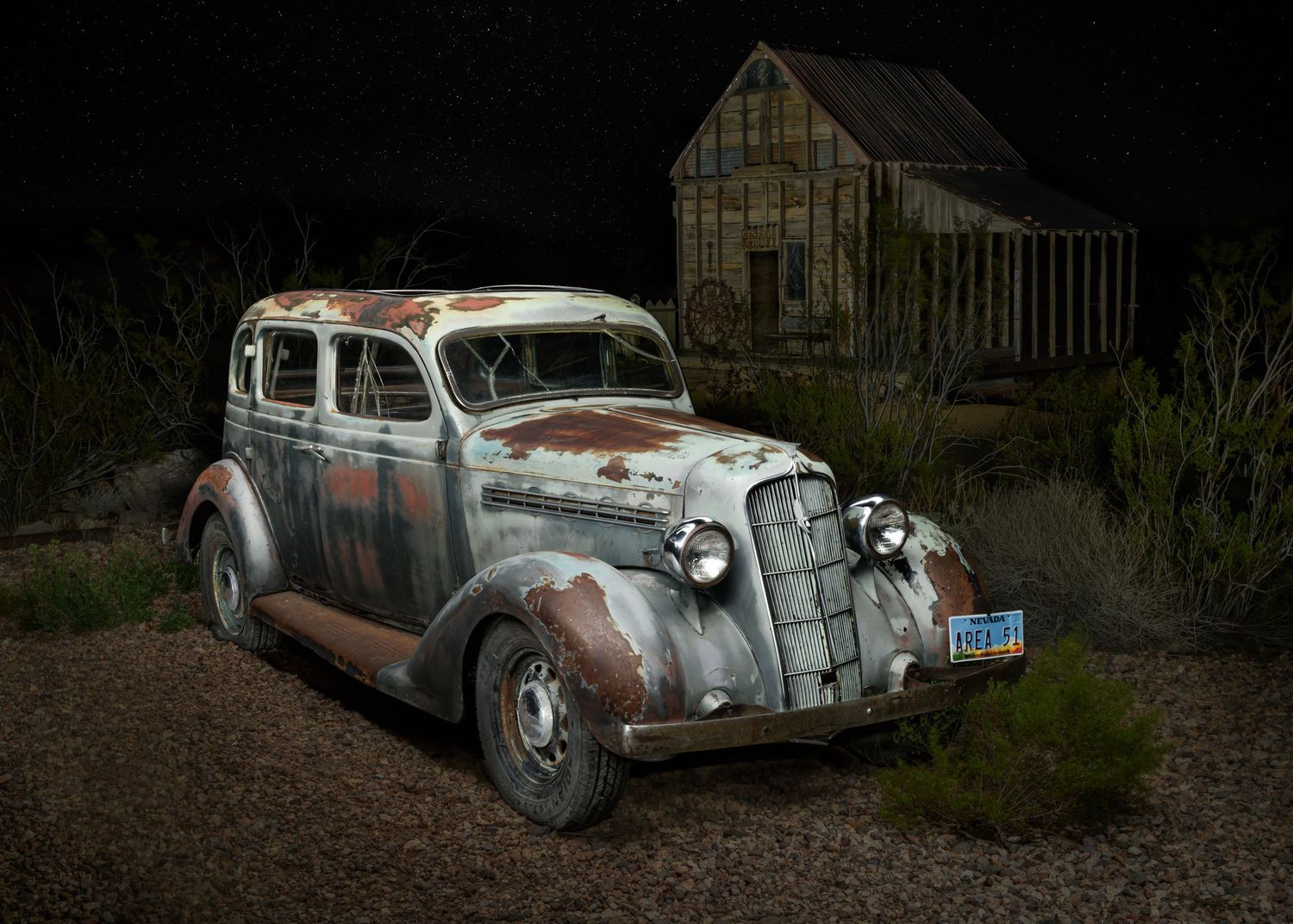 John Gayler light painting fine art wall portrait of 1936 Plymouth P2 sedan at Nelson Ghost Town Nevada with barn and starry sky Area 51