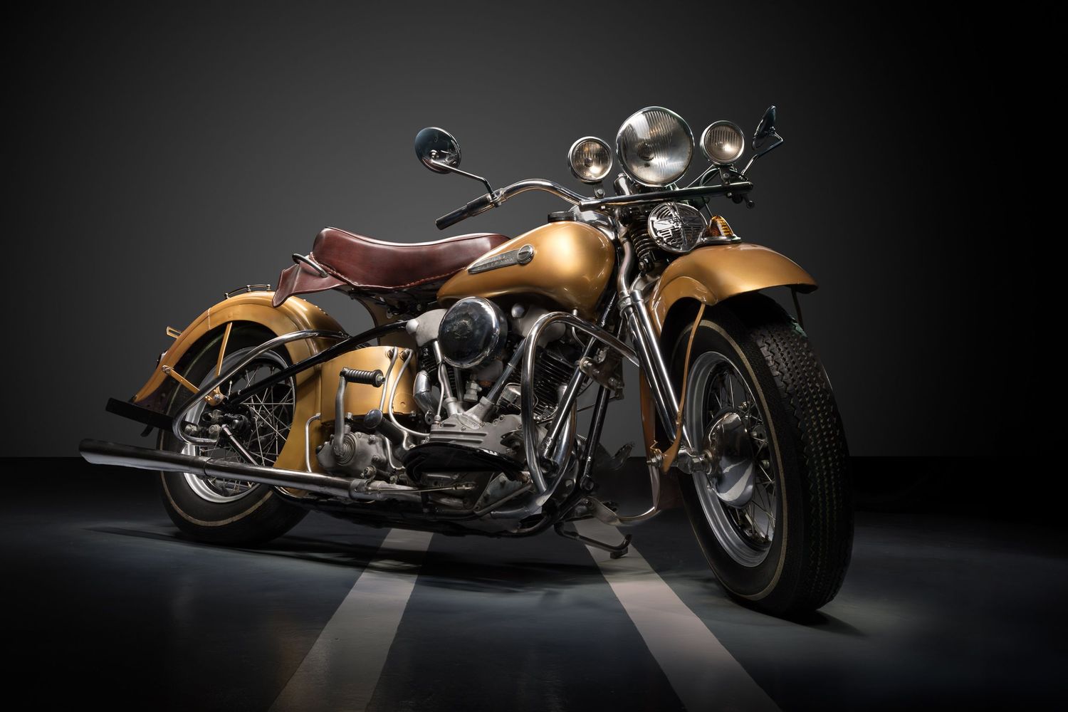 A  classic 1942 Harley Davidson Knucklehead motorcycle with gold paint in a fine art light painting portrait by john Gayler Photography.