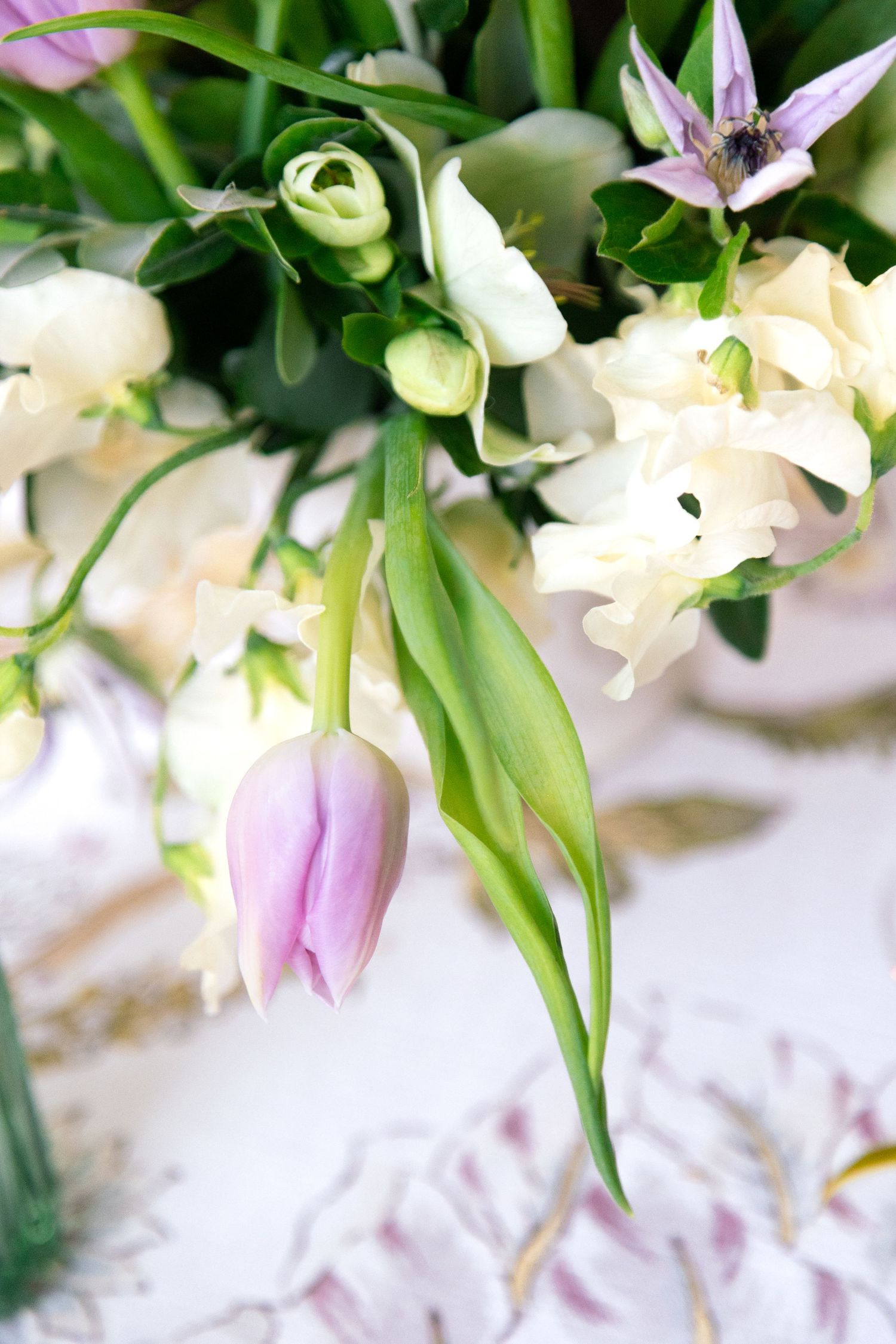 Delicate arrangement of white and pink lilies with green foliage.